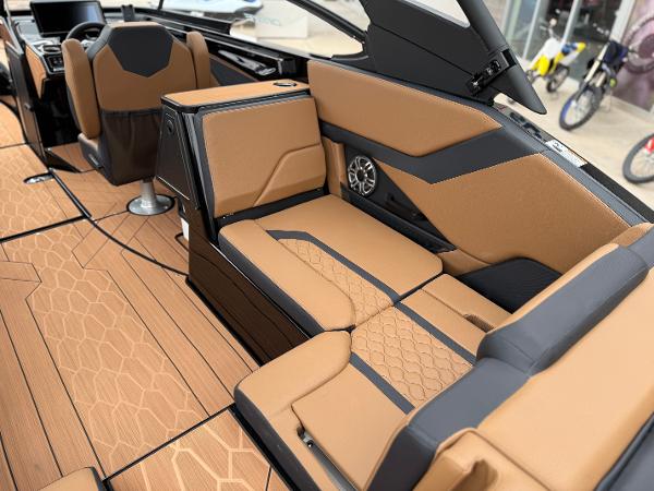 2025 Yamaha Boats 255XD interior with tan and black seating, modern design, and speaker system.