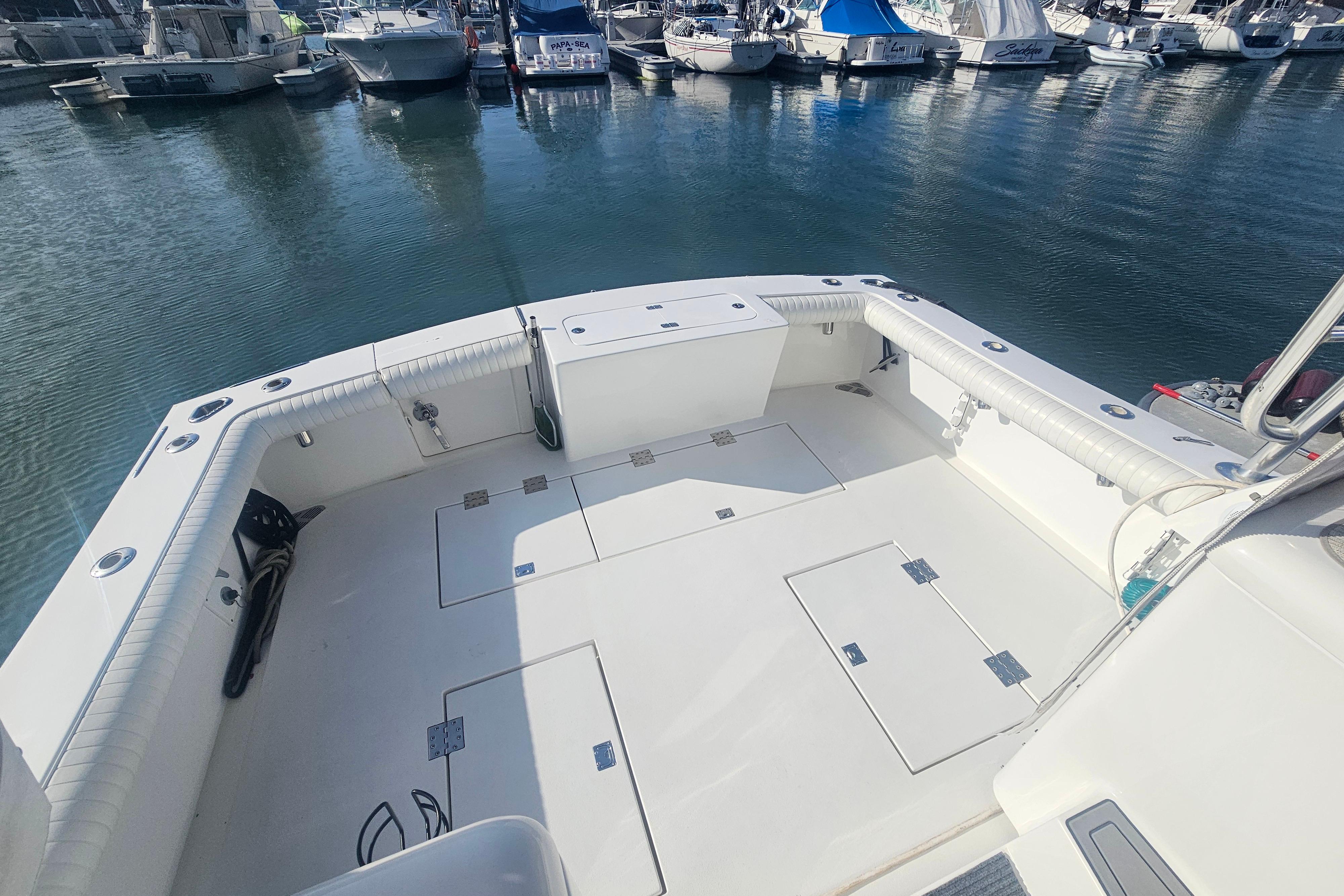 2003 Topaz 32 Express boat deck with marina view, featuring spacious seating and storage.