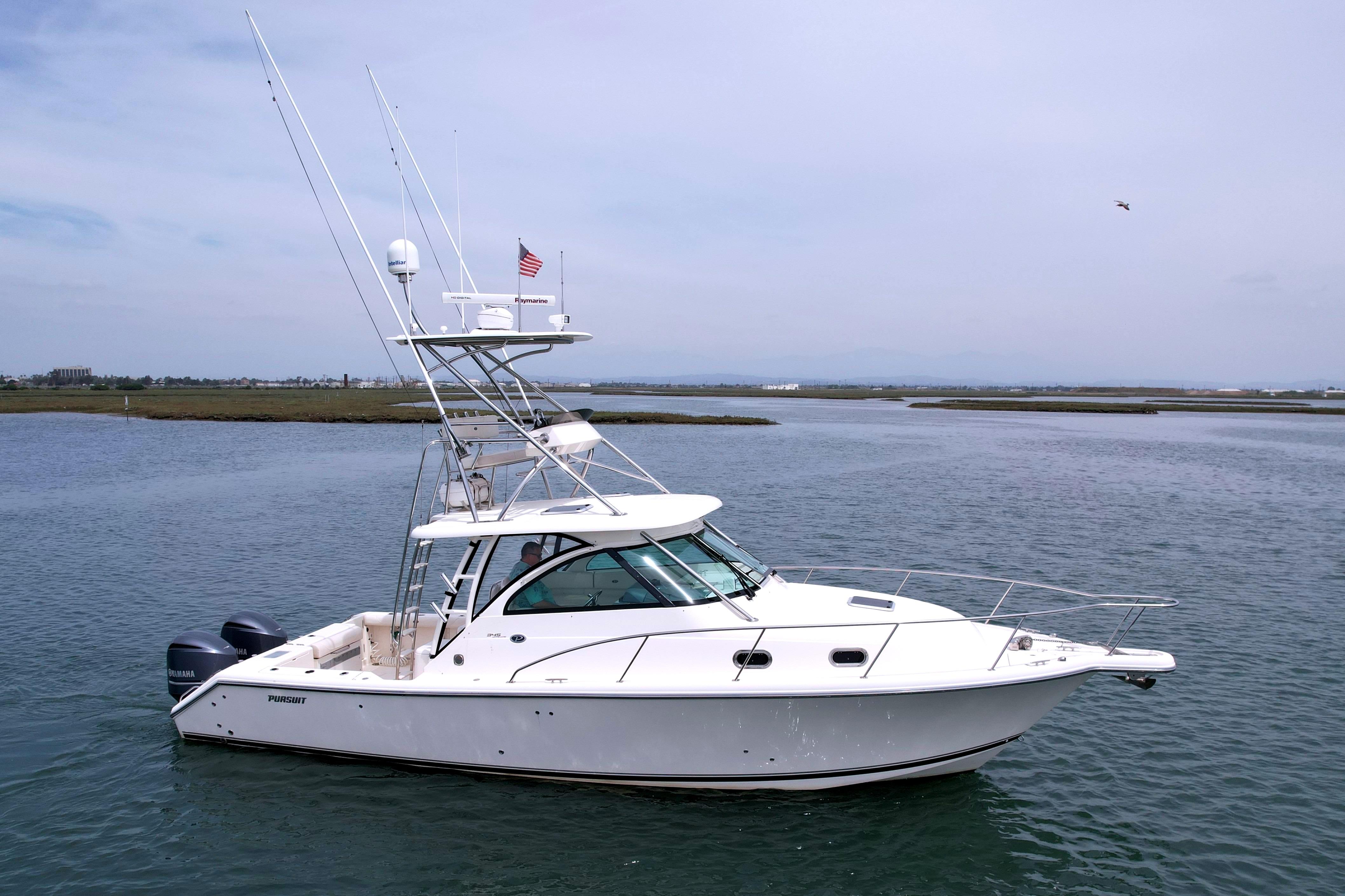 2012 Pursuit OS 345 Offshore boat on calm water, featuring dual engines and radar equipment.