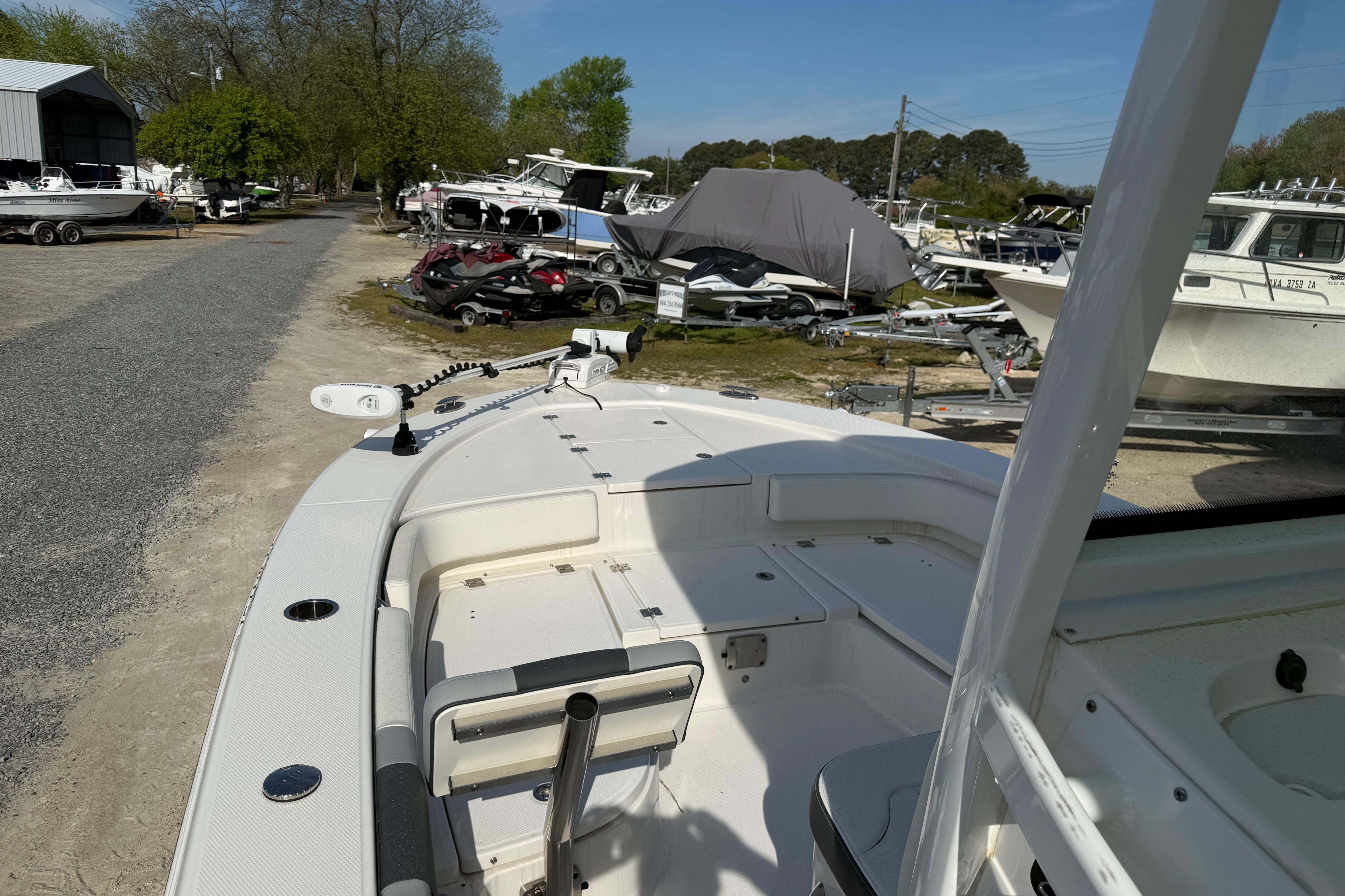 2023 Robalo 246 Cayman boat at a marina with surrounding boats and trailers.