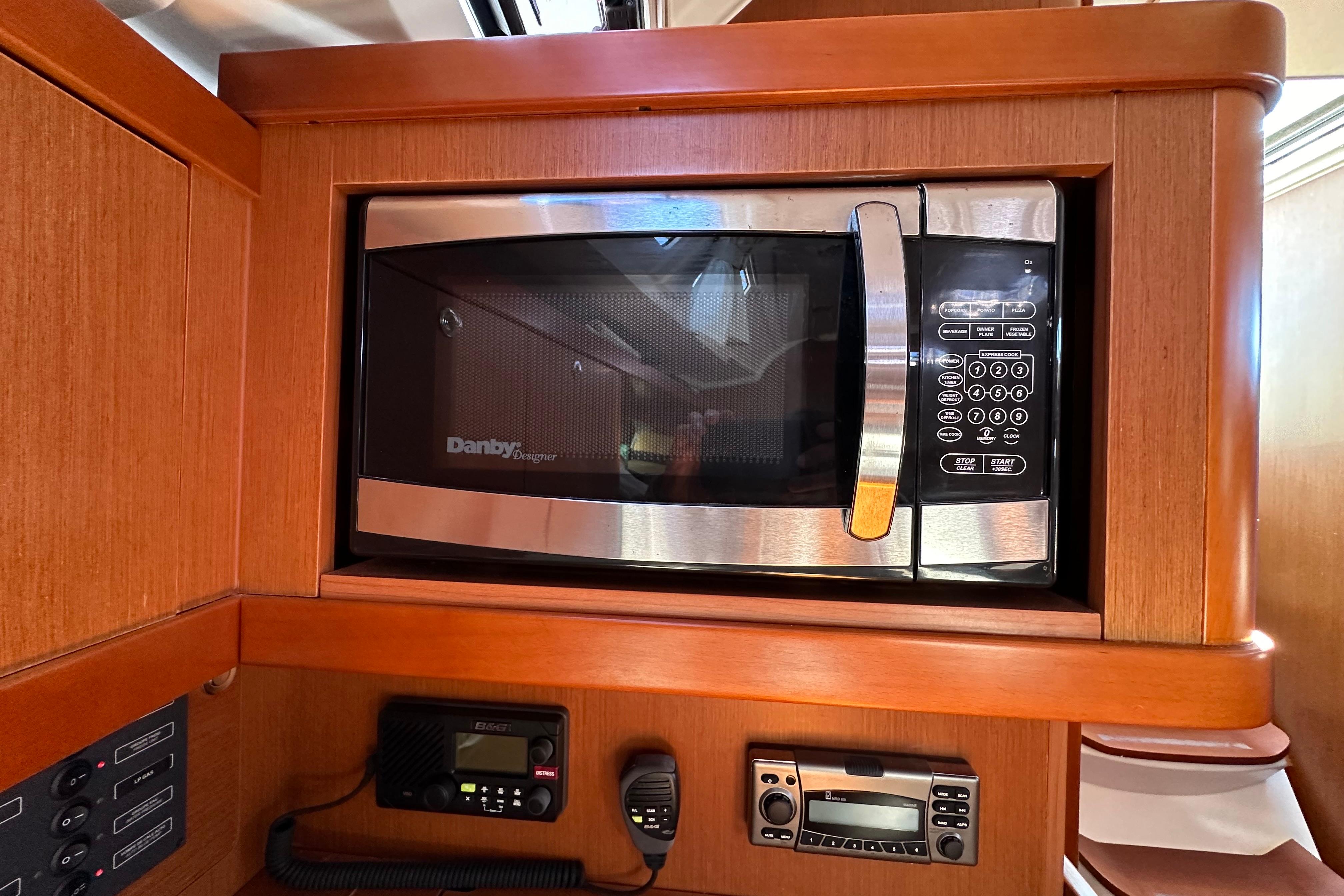 Microwave and control panel inside 2015 Beneteau Oceanis 37 yacht kitchen.
