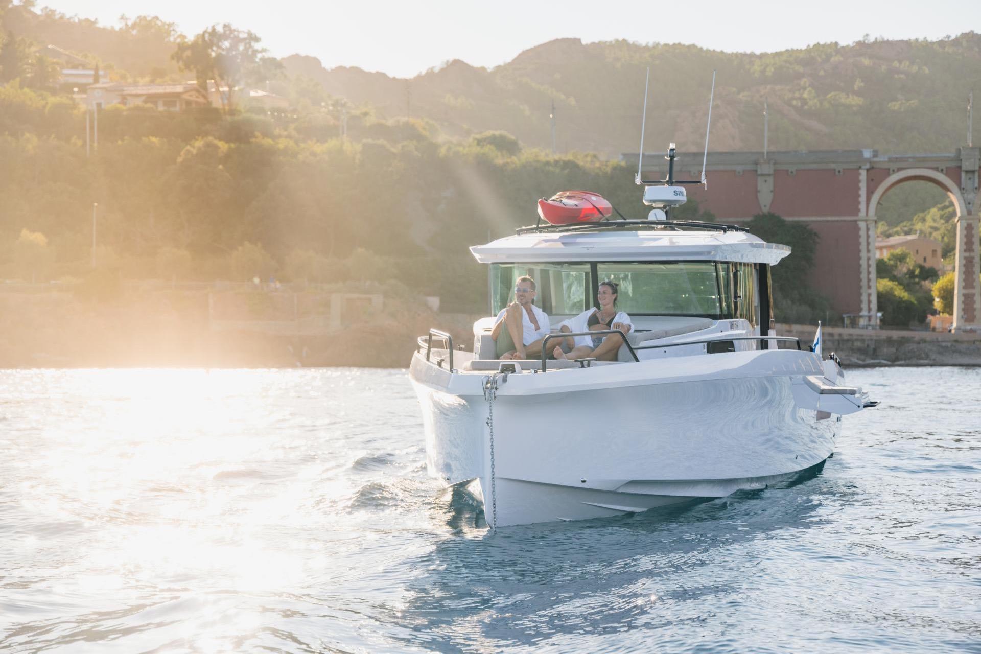 2027 Axopar 45 XC Cross Cabin cruising on sunny waters near scenic coastline.