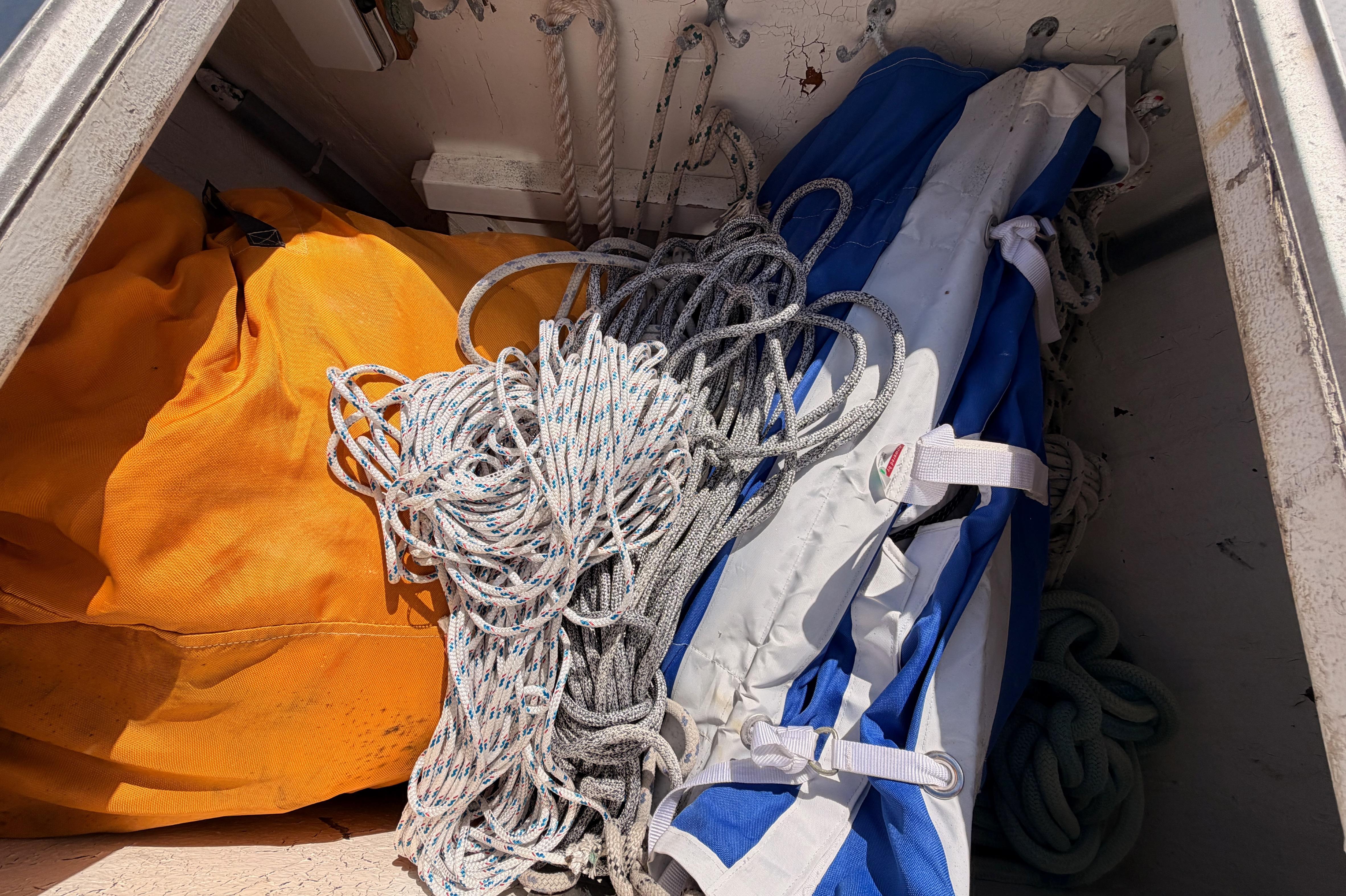 Storage compartment of a 1991 Hylas 51 sailboat with ropes and sails.