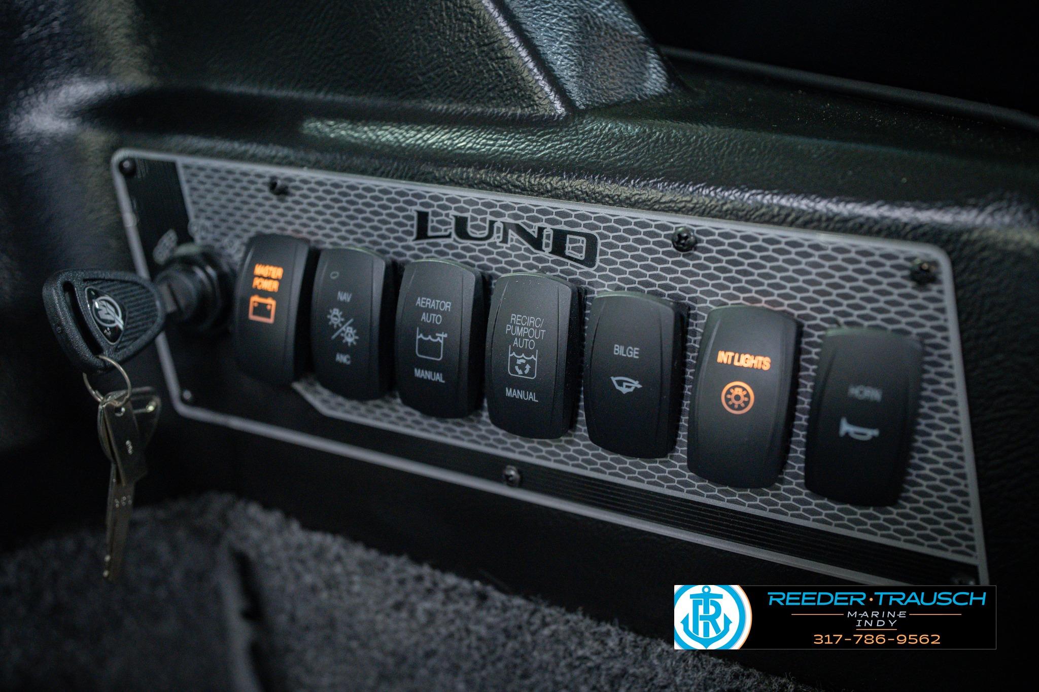Control panel of 2026 Lund 1775 Impact XS boat with various switches and key ignition.