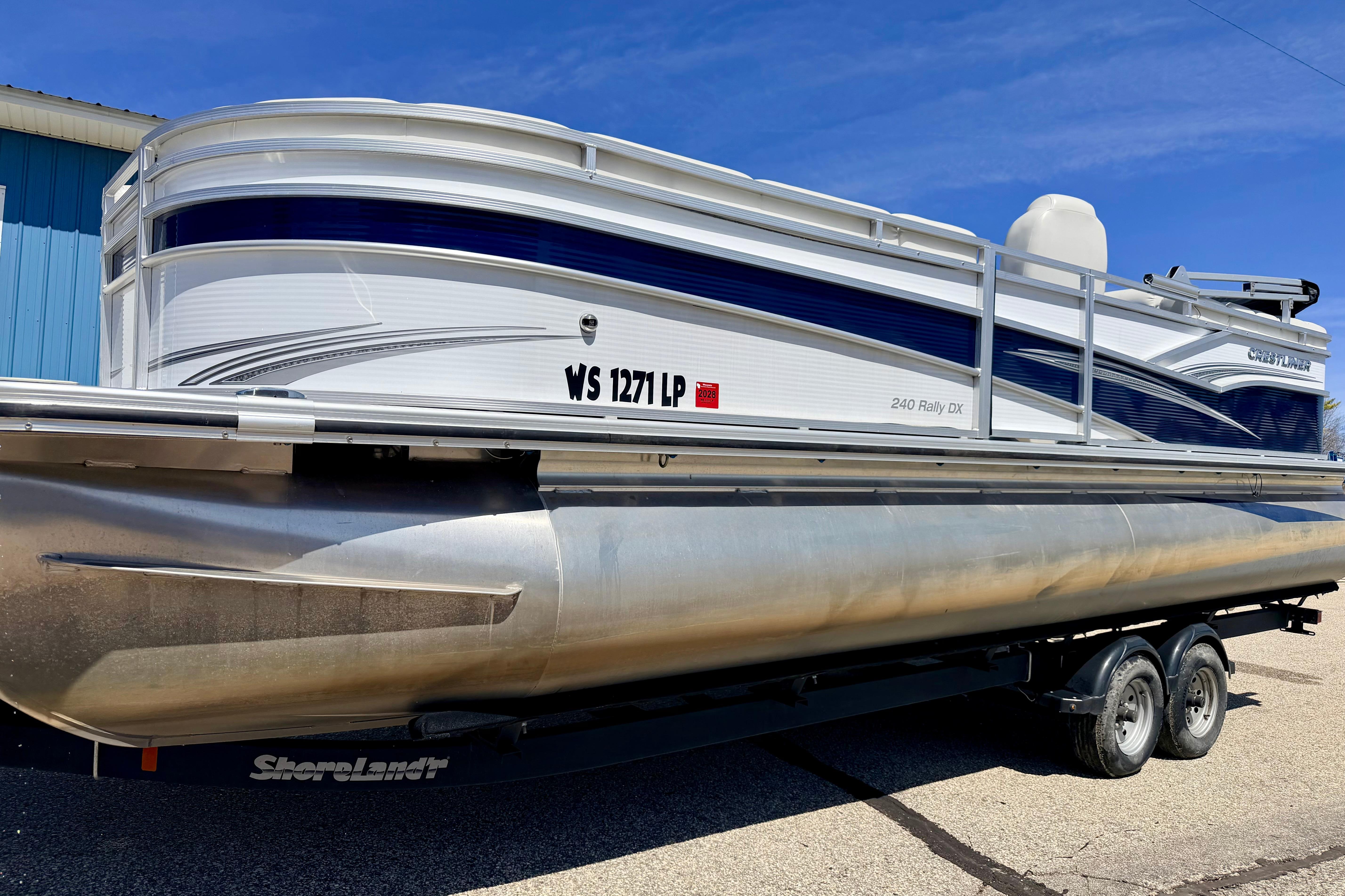 2019 Crestliner 240 Rally DX CW pontoon boat on trailer, side view.