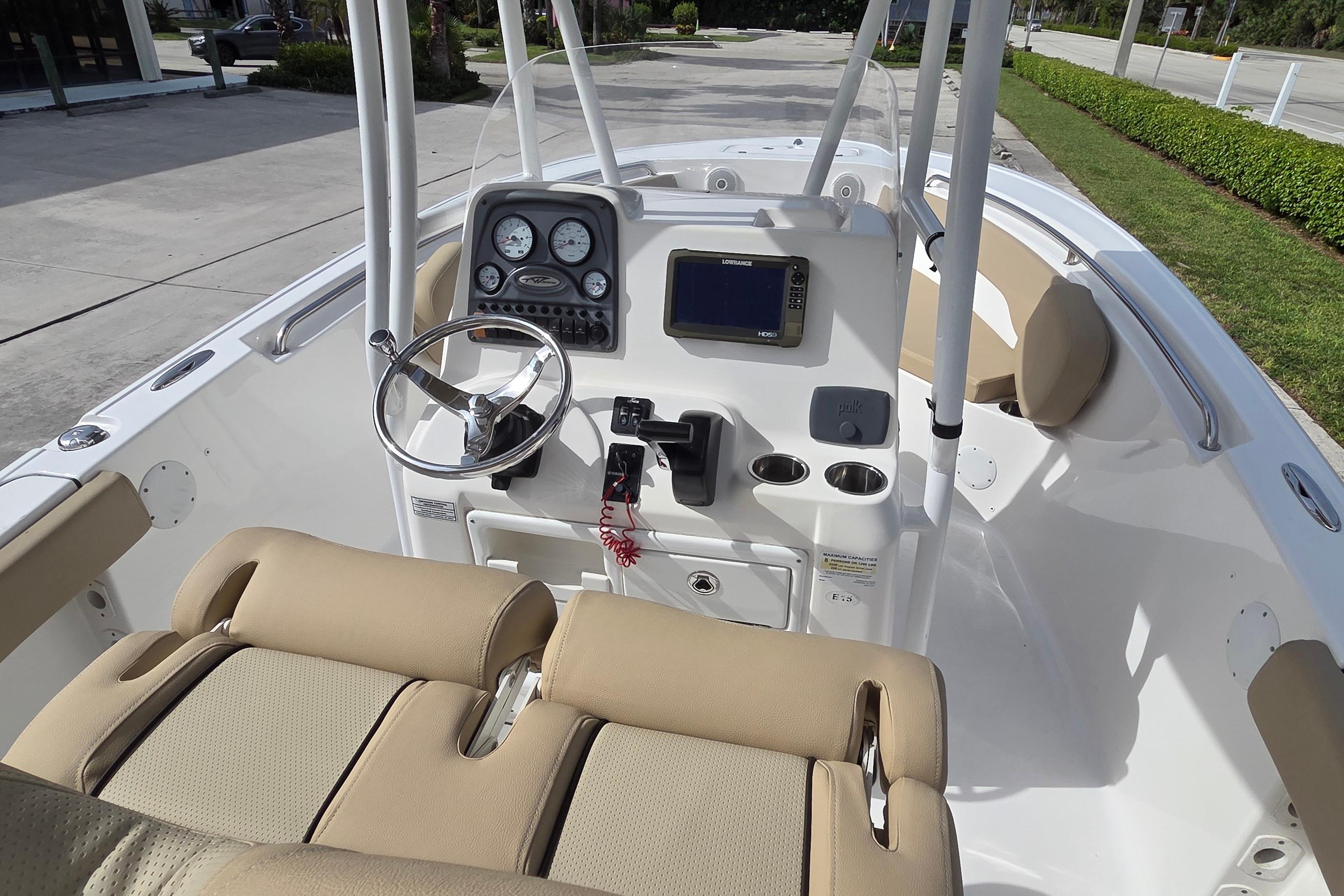 2015 Tidewater 220 LXF boat interior with steering console and beige seating.