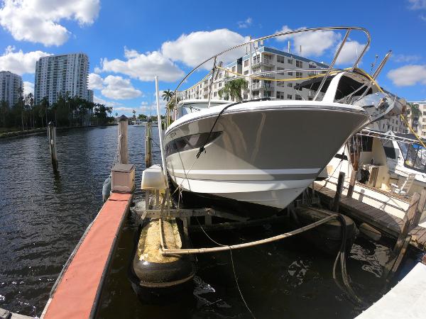 2017 Jeanneau NC 11 boat docked at a marina with waterfront buildings.