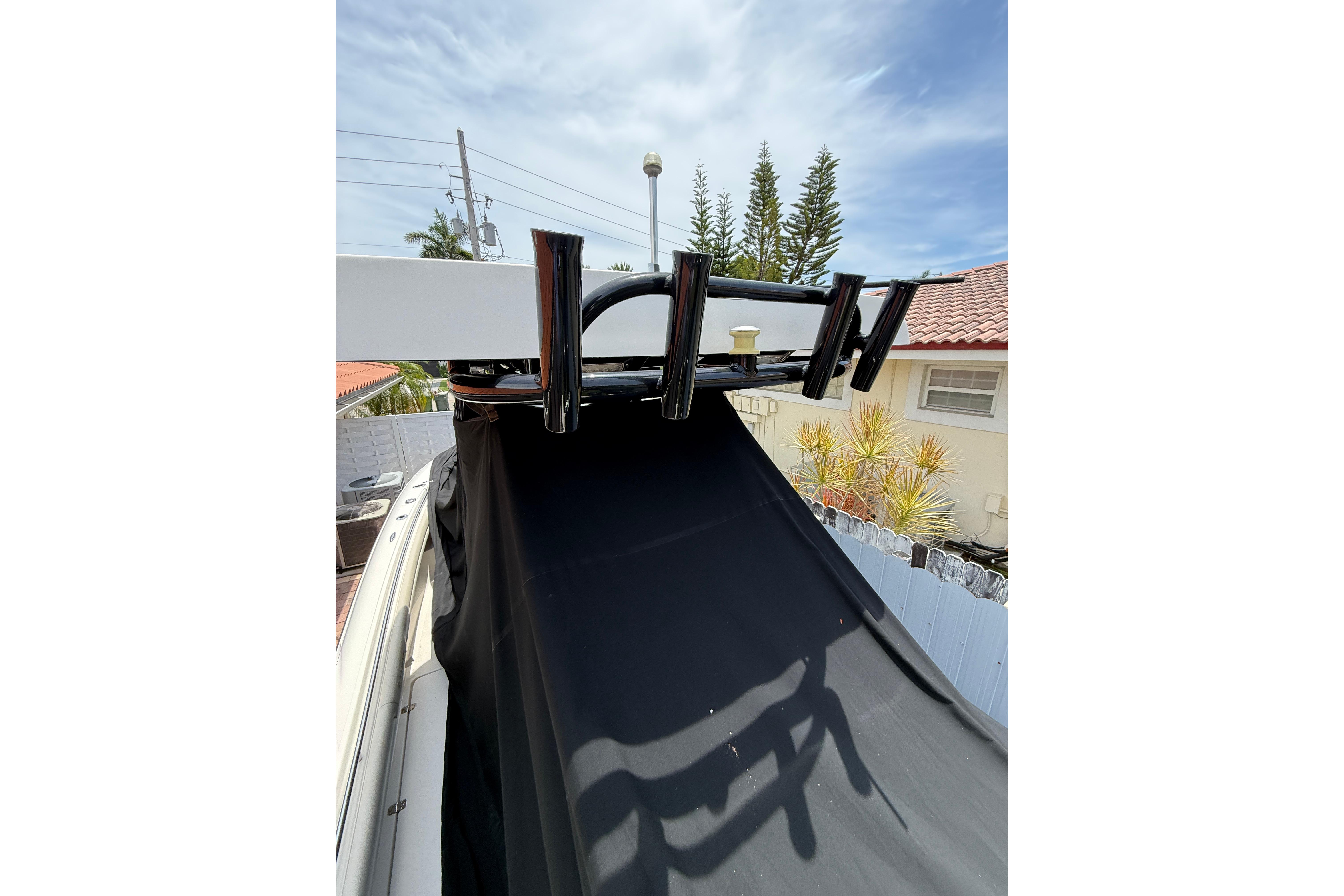 Boat with black cover and rod holders, Blackwood 27, 2015 model, sunny day.