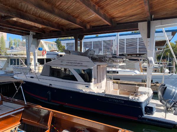 2021 Cutwater C-32 CB boat docked under a wooden shelter.