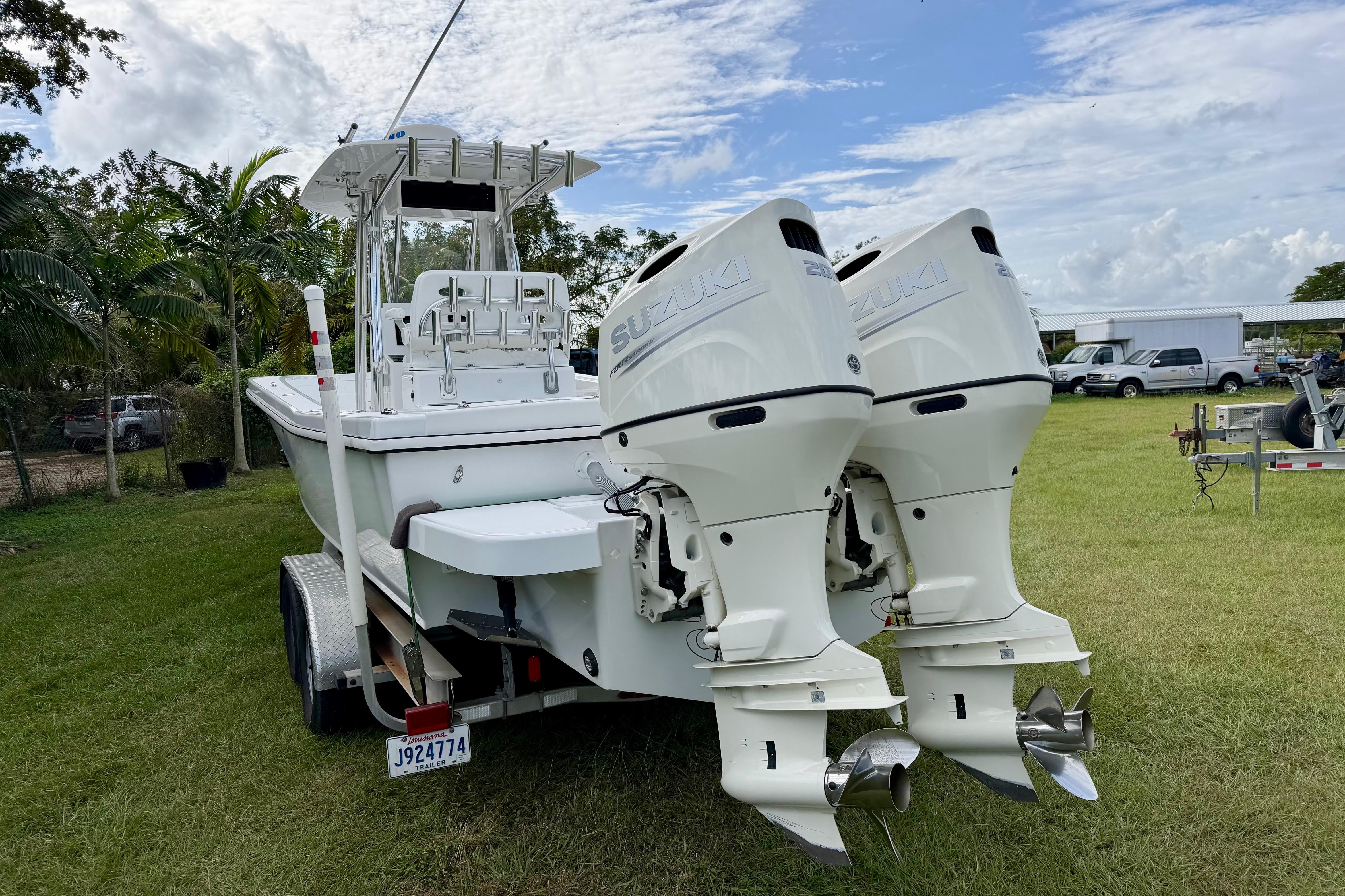 2025 Ocean Master 296 Center Console boat with twin Suzuki outboard engines on a trailer.