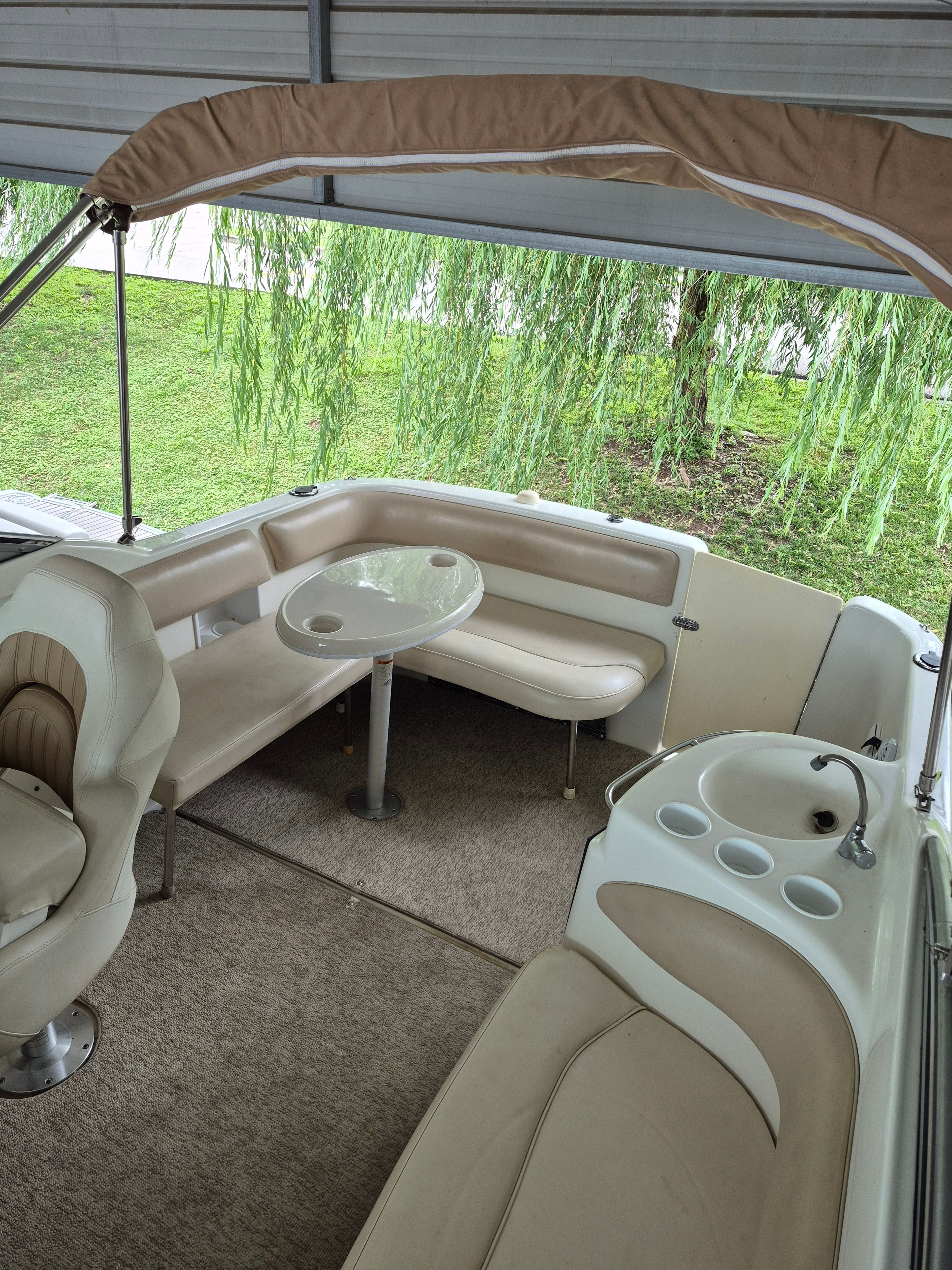 The image shows the cockpit of a 2004 Larson Cabrio 274 with seating and a table.