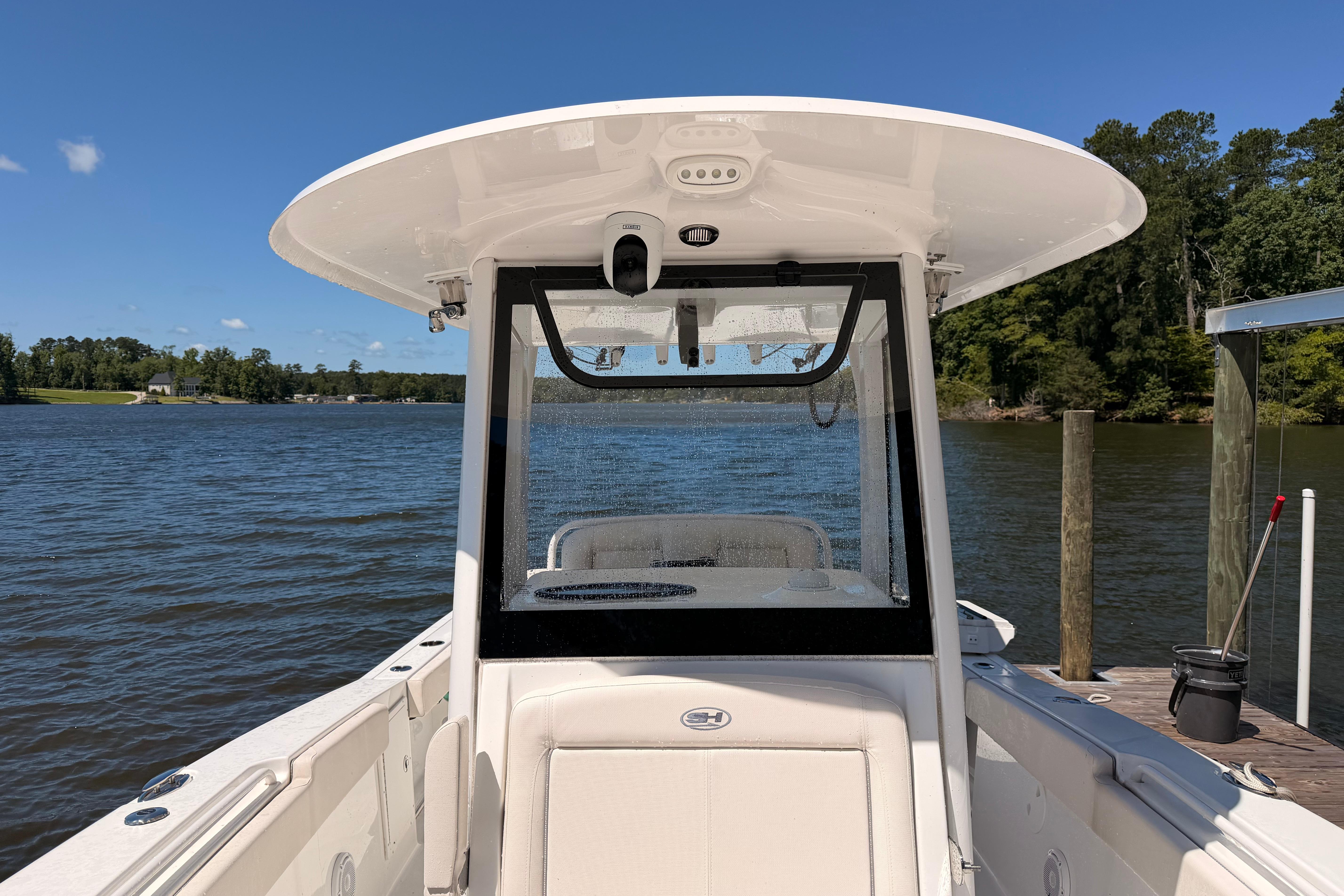 2024 Sea Hunt Gamefish 27 Coffin Box boat docked on a sunny lake.