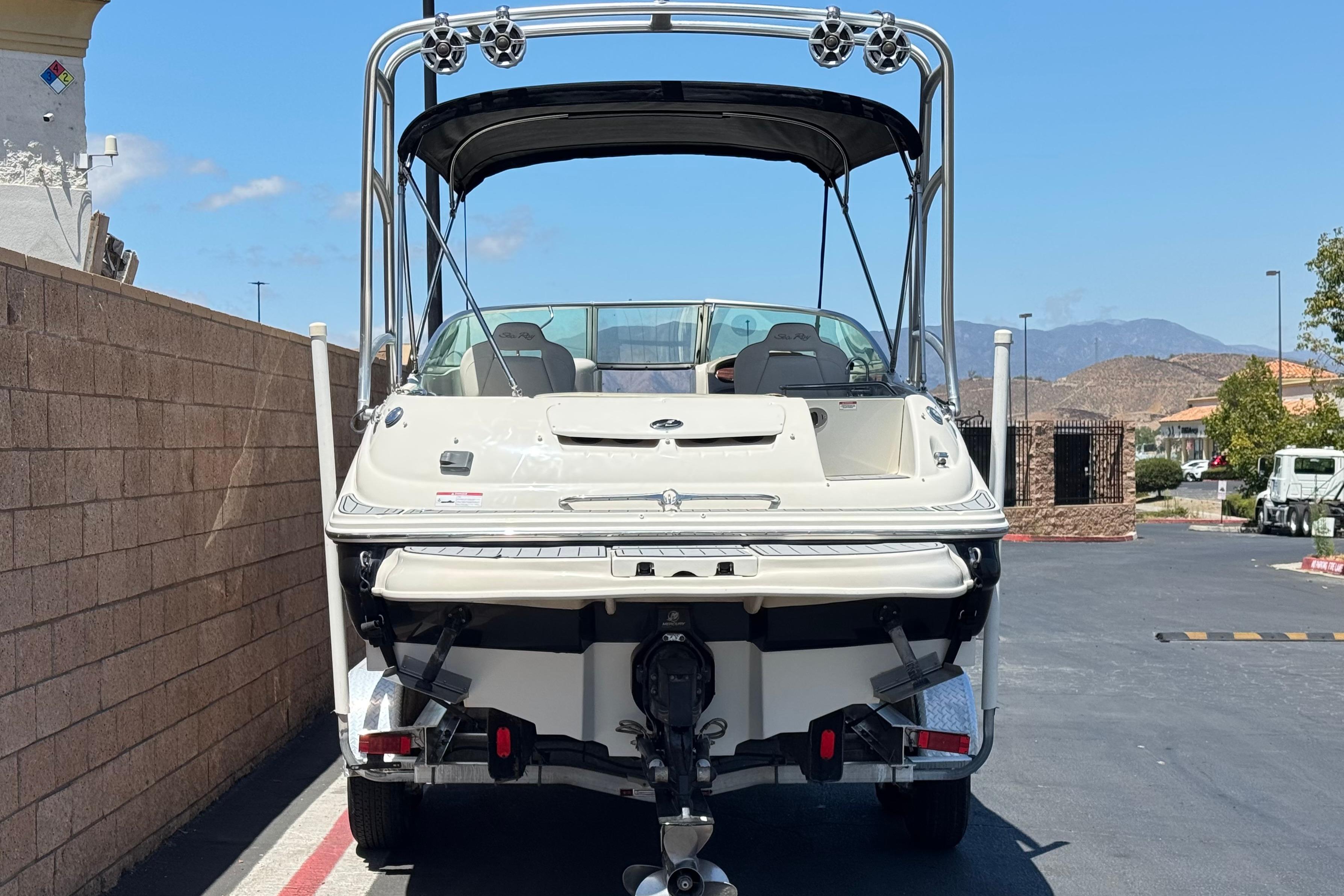 2007 Sea Ray 240 Sundeck boat on trailer, parked outdoors with clear sky.