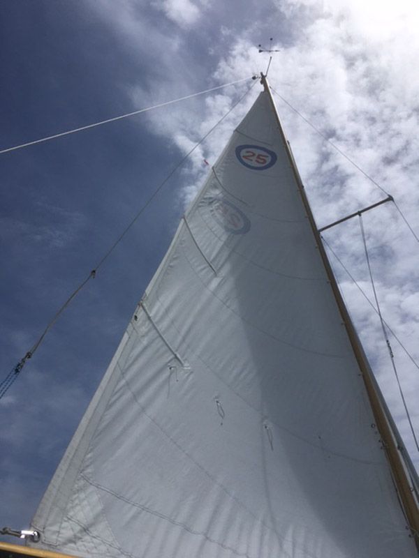 1975 O'Day Sloop sailboat against a blue sky.