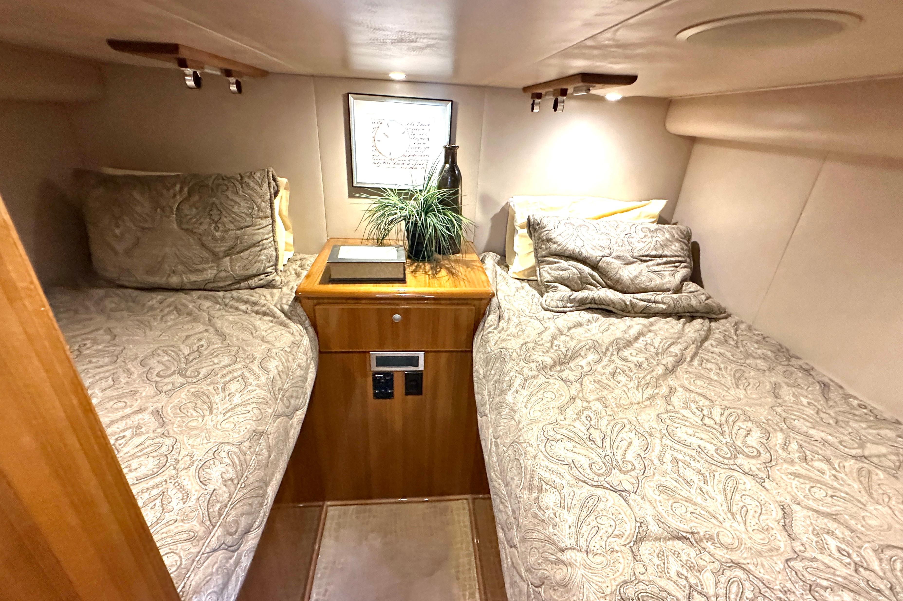 Luxurious cabin interior of 2012 Viking 42 Open yacht with twin beds and elegant decor.