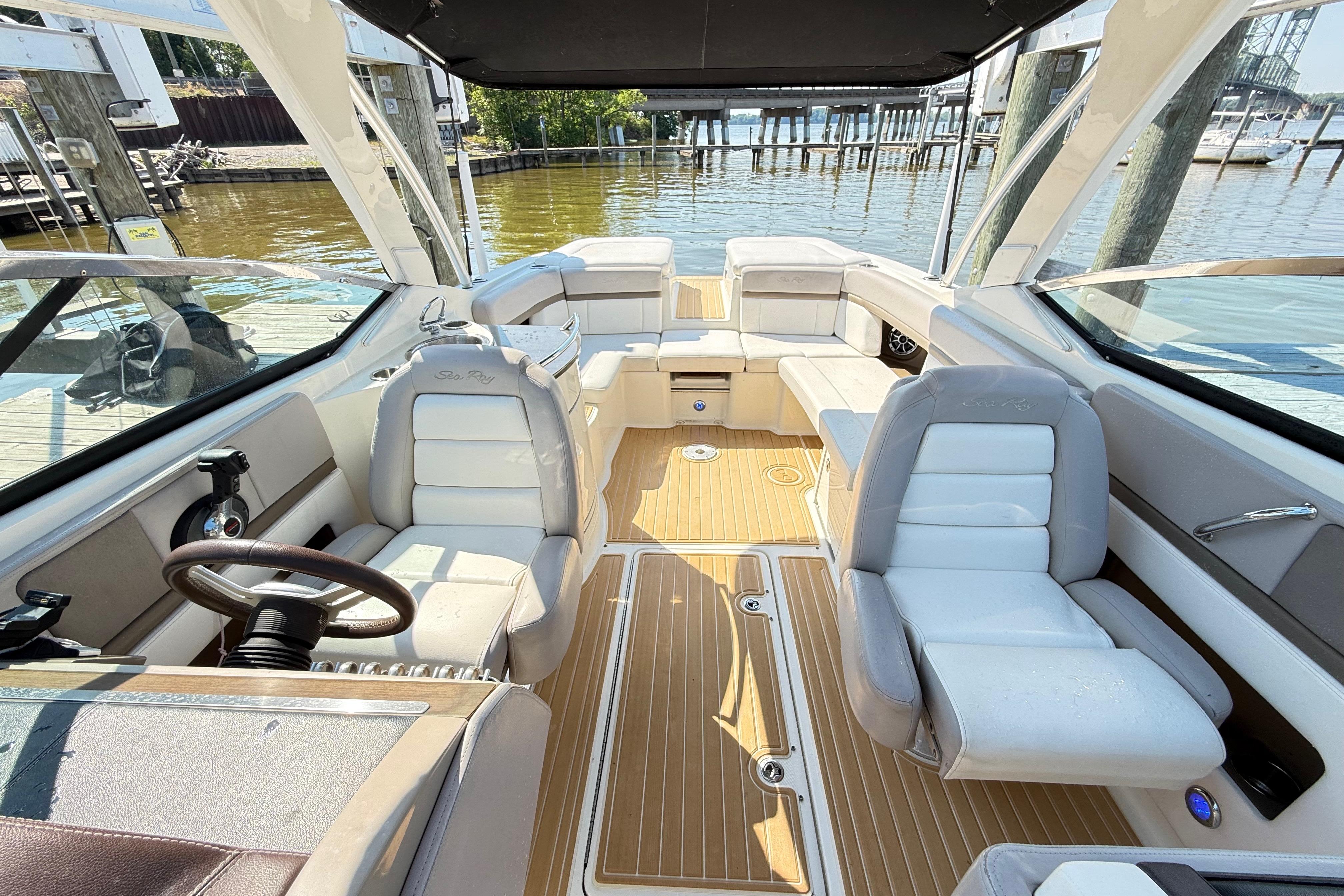 Interior view of a 2011 Sea Ray 270 SLX boat with luxurious seating and wood flooring.