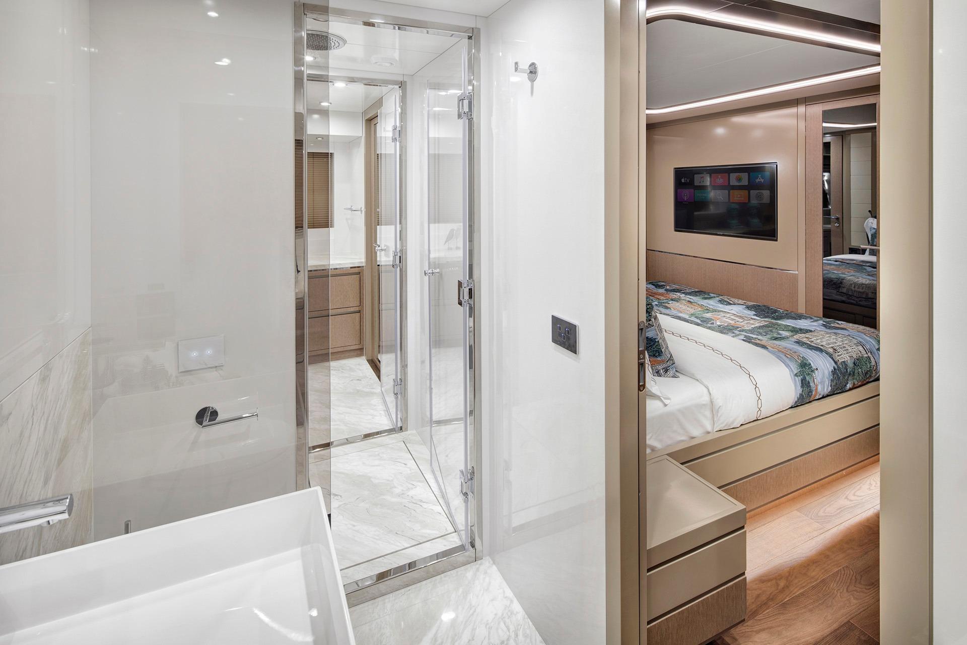 Luxurious interior of 2026 Sirena 68 yacht featuring modern bathroom and cozy bedroom.