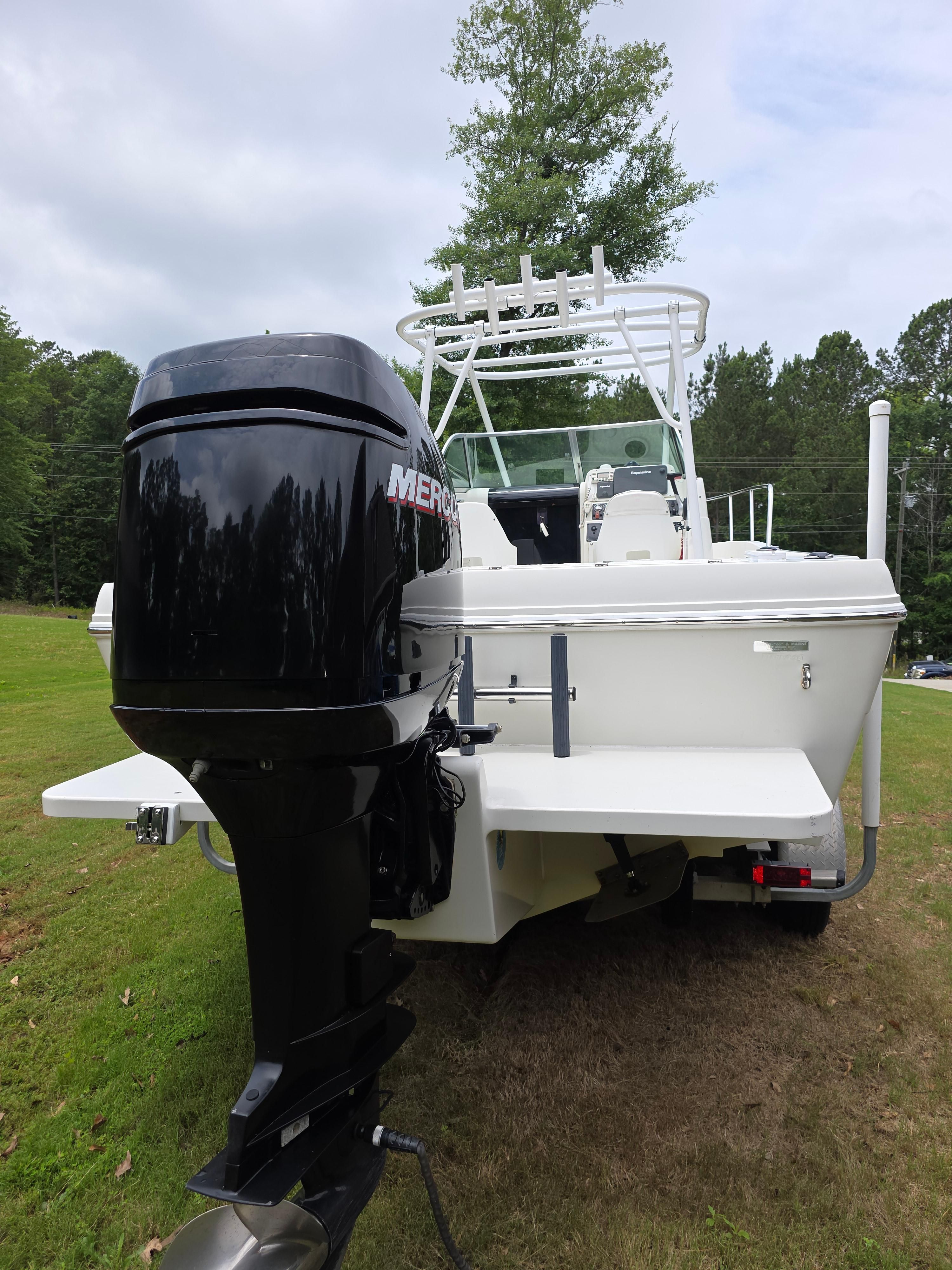 A 2005 Caravelle Sea Hawk 230 Walk Around OB on grass. The outboard motor is visible.