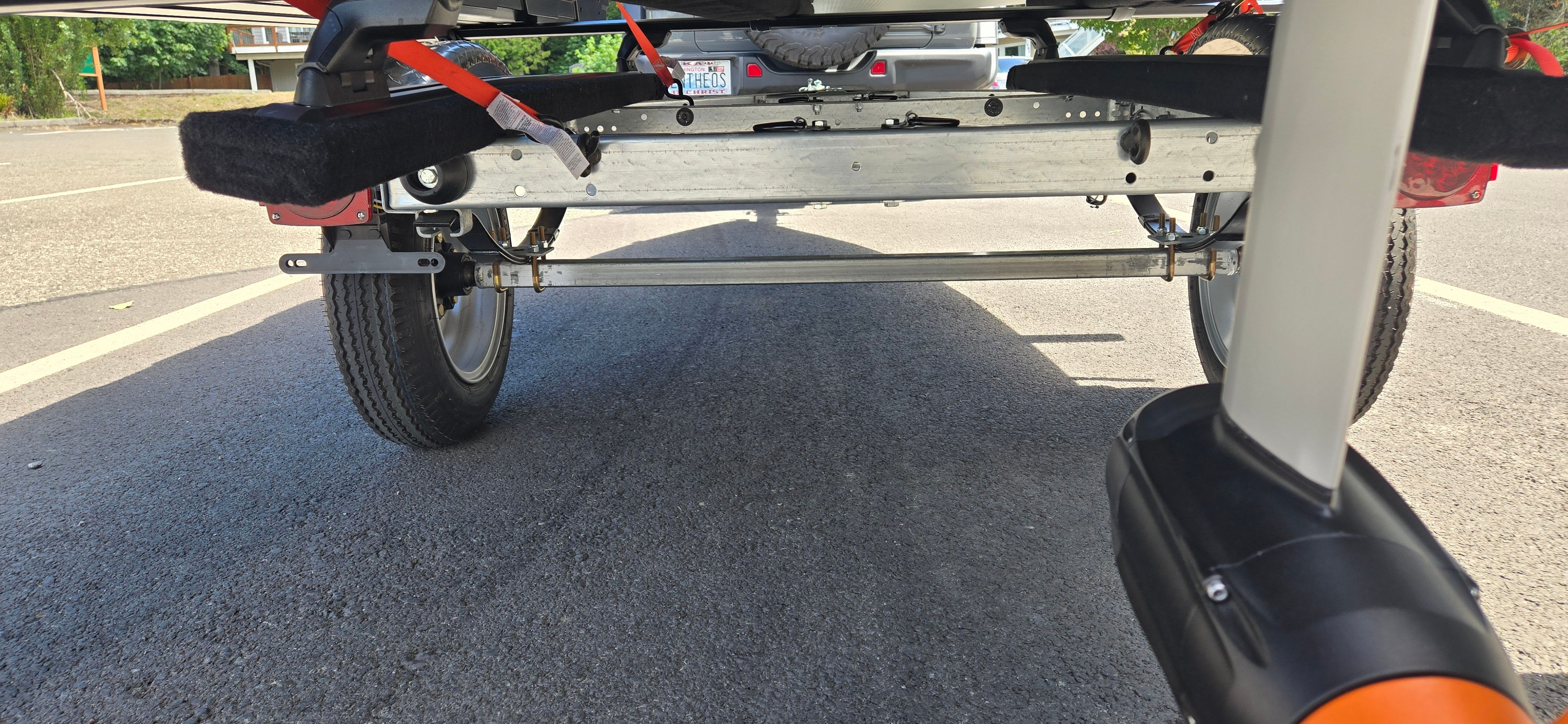 Close-up of a boat trailer with wheels on a parking lot.