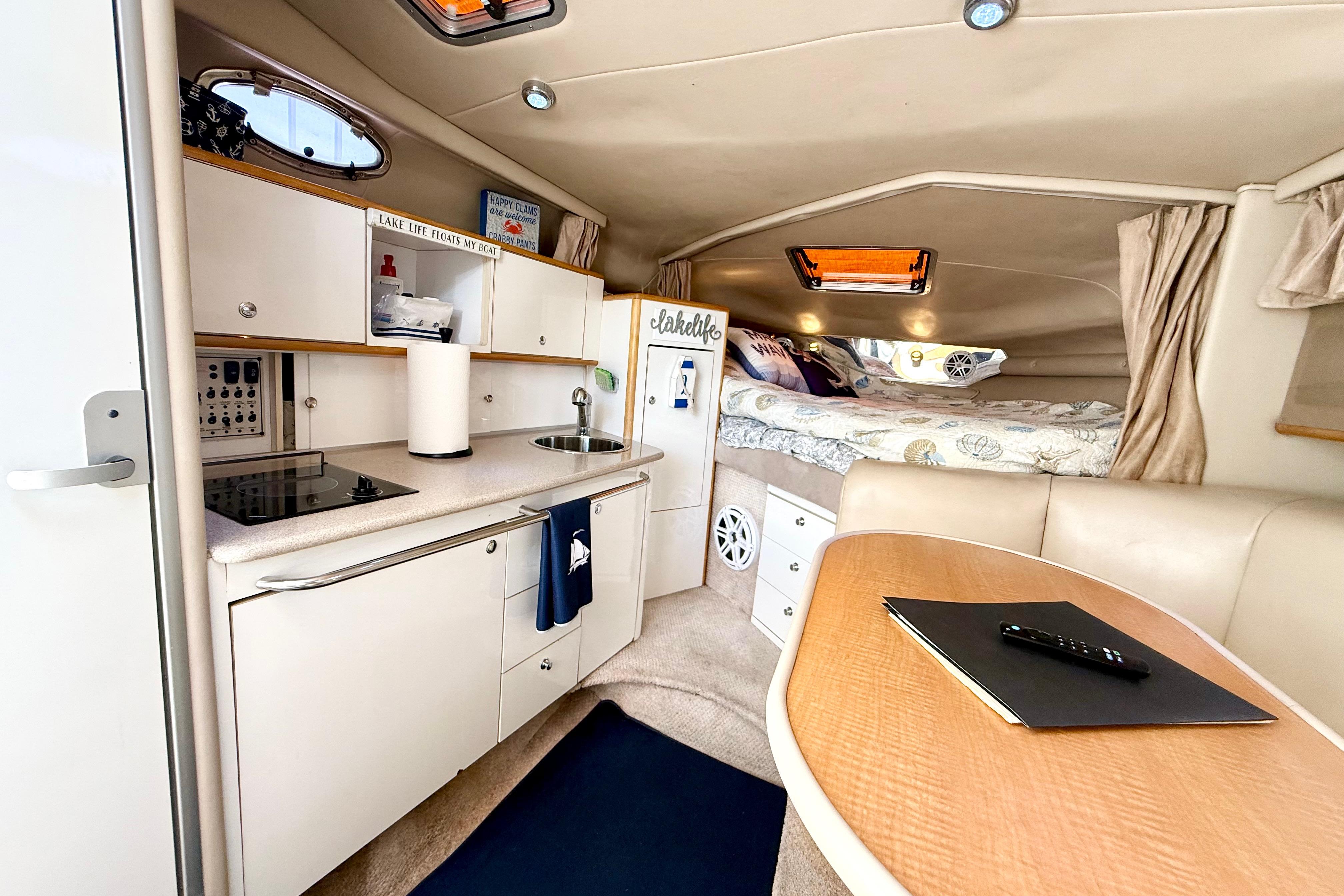 1999 Chaparral Signature 300 cabin interior with kitchenette, dining area, and cozy sleeping quarters.