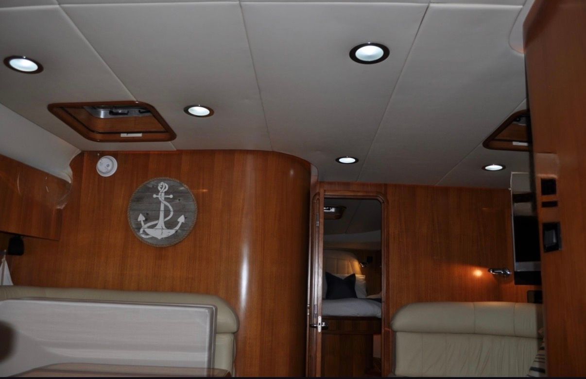 Interior of a 2005 Tiara Yachts 5200 Sovran with wood paneling and round ceiling lights.