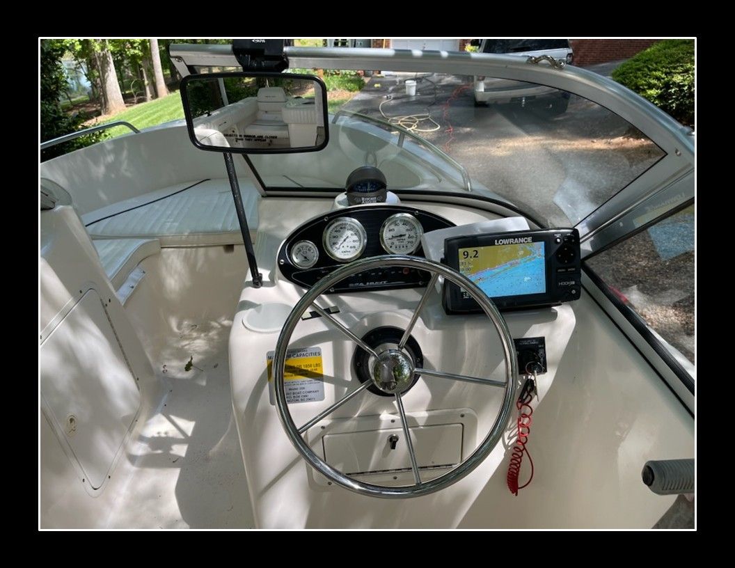 The image shows the helm of a 2004 Sea Hunt Escape boat with navigation system.