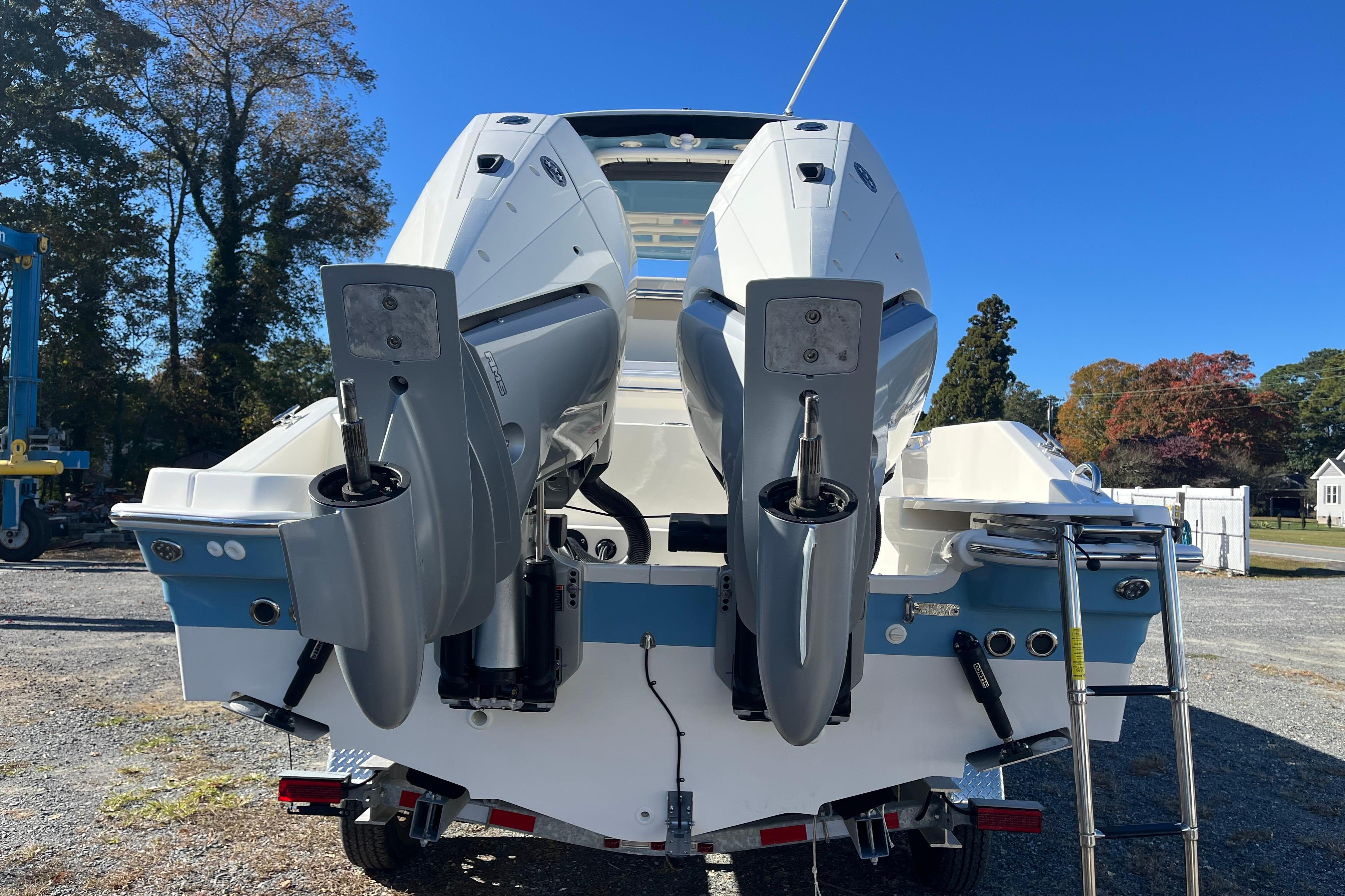 2026 Boston Whaler 280 Dauntless boat with dual outboard engines, parked outdoors.