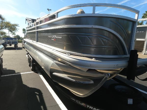 2024 Sun Tracker Fishin' Barge 22 XP3 pontoon boat in a parking lot.