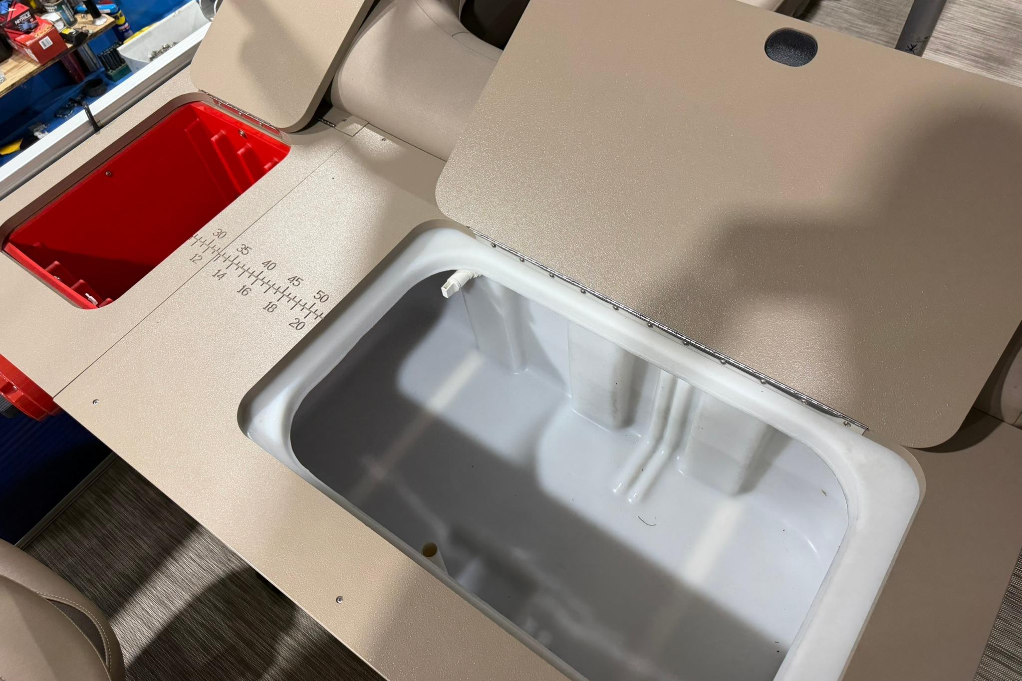 2020 Bennington SX 22 SFX boat storage compartments with measuring scale.
