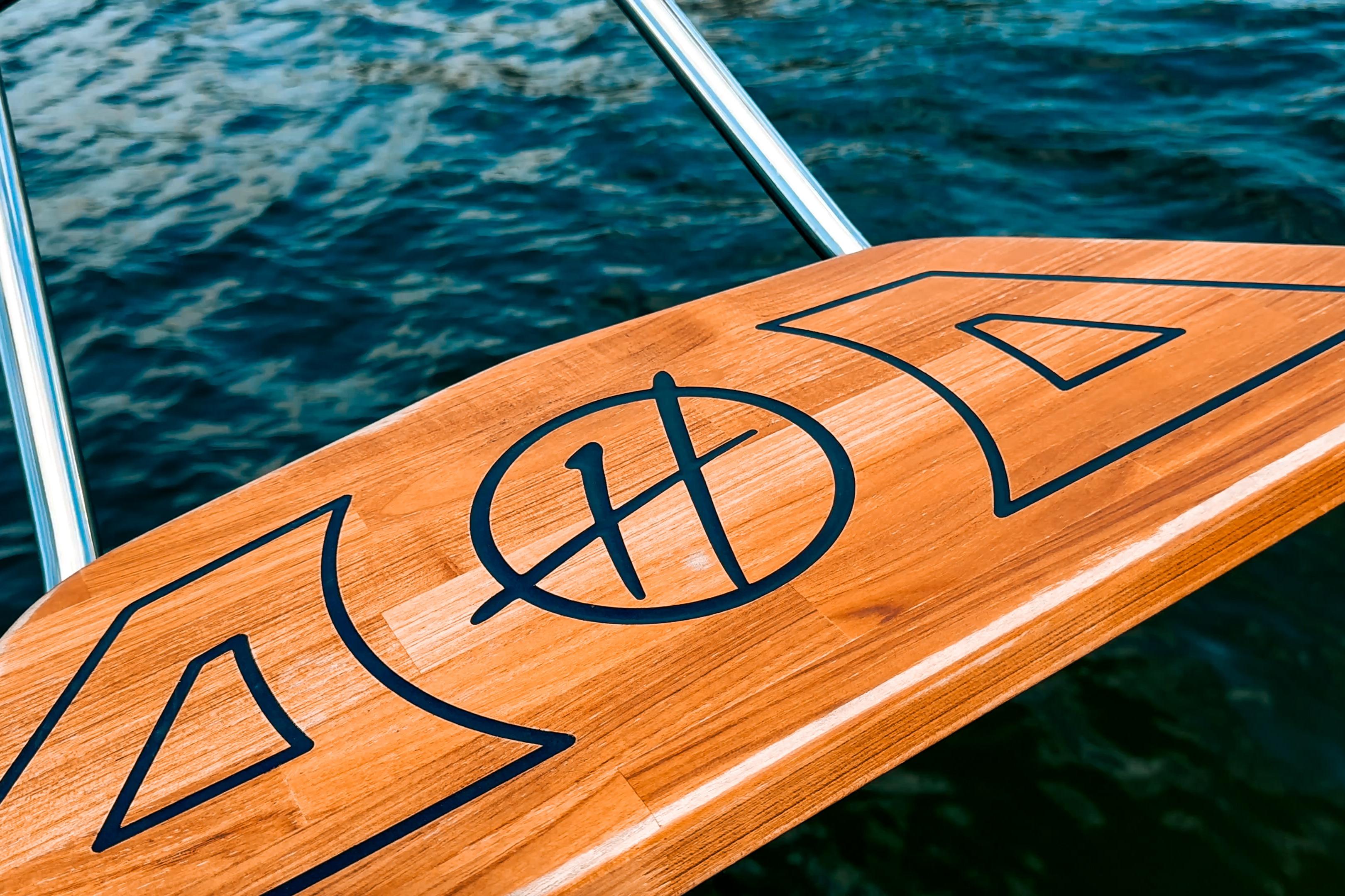 Wooden deck of Hanover 305 boat, 2027 model, with water in the background.