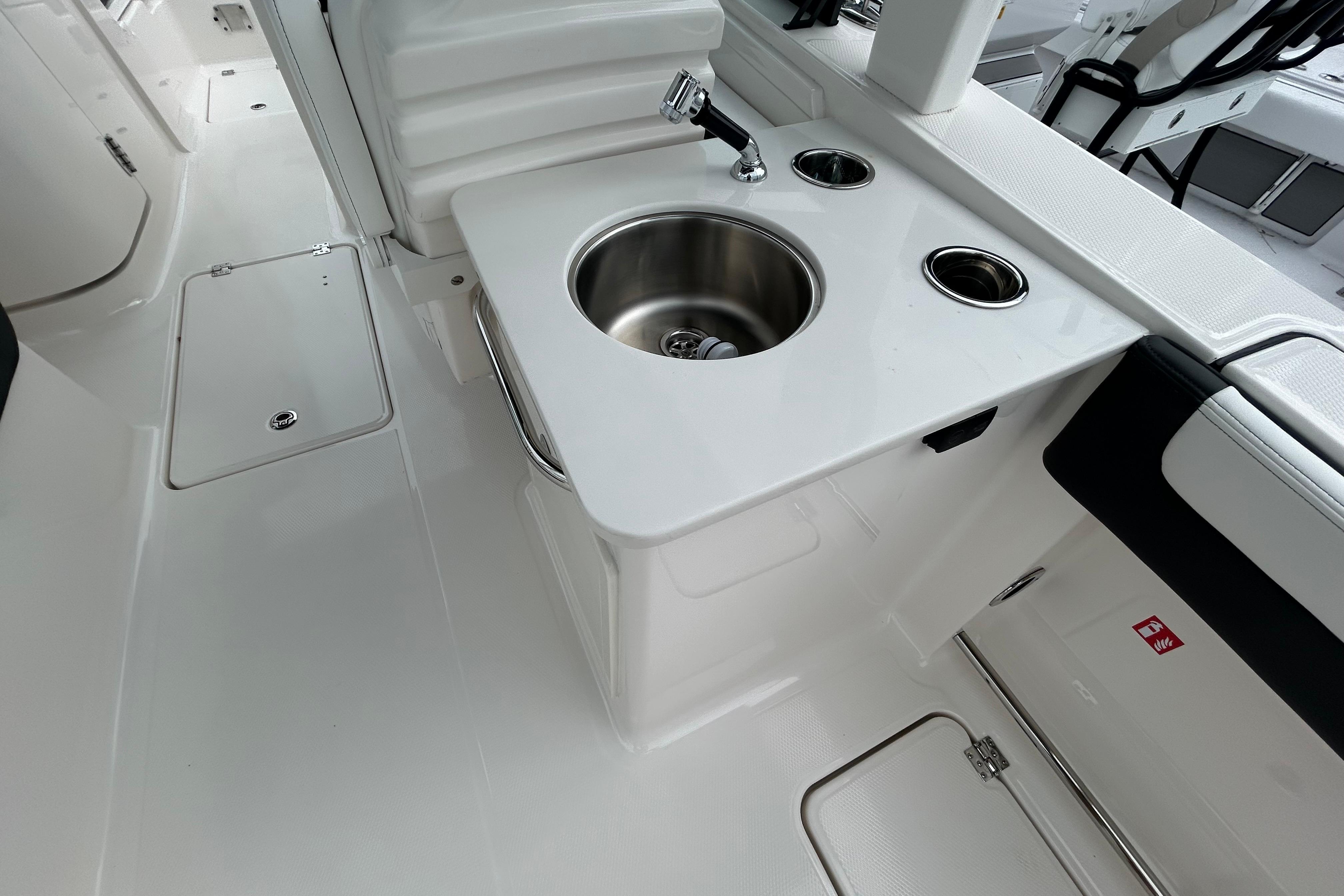 2026 Robalo R257 Dual Console boat interior with sink and seating area.