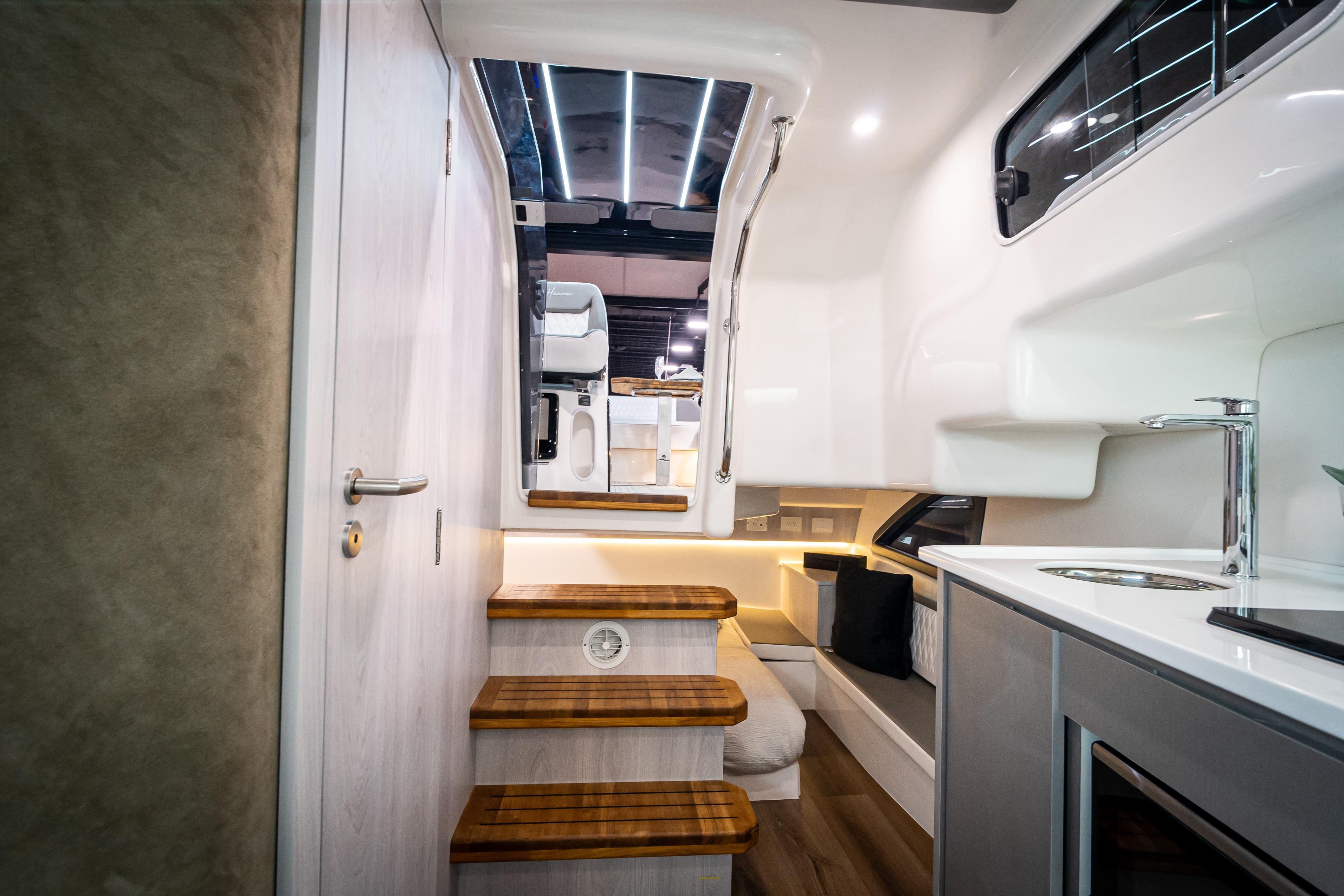 Interior of 2026 Hanover 347 yacht, featuring modern kitchen and wooden steps.
