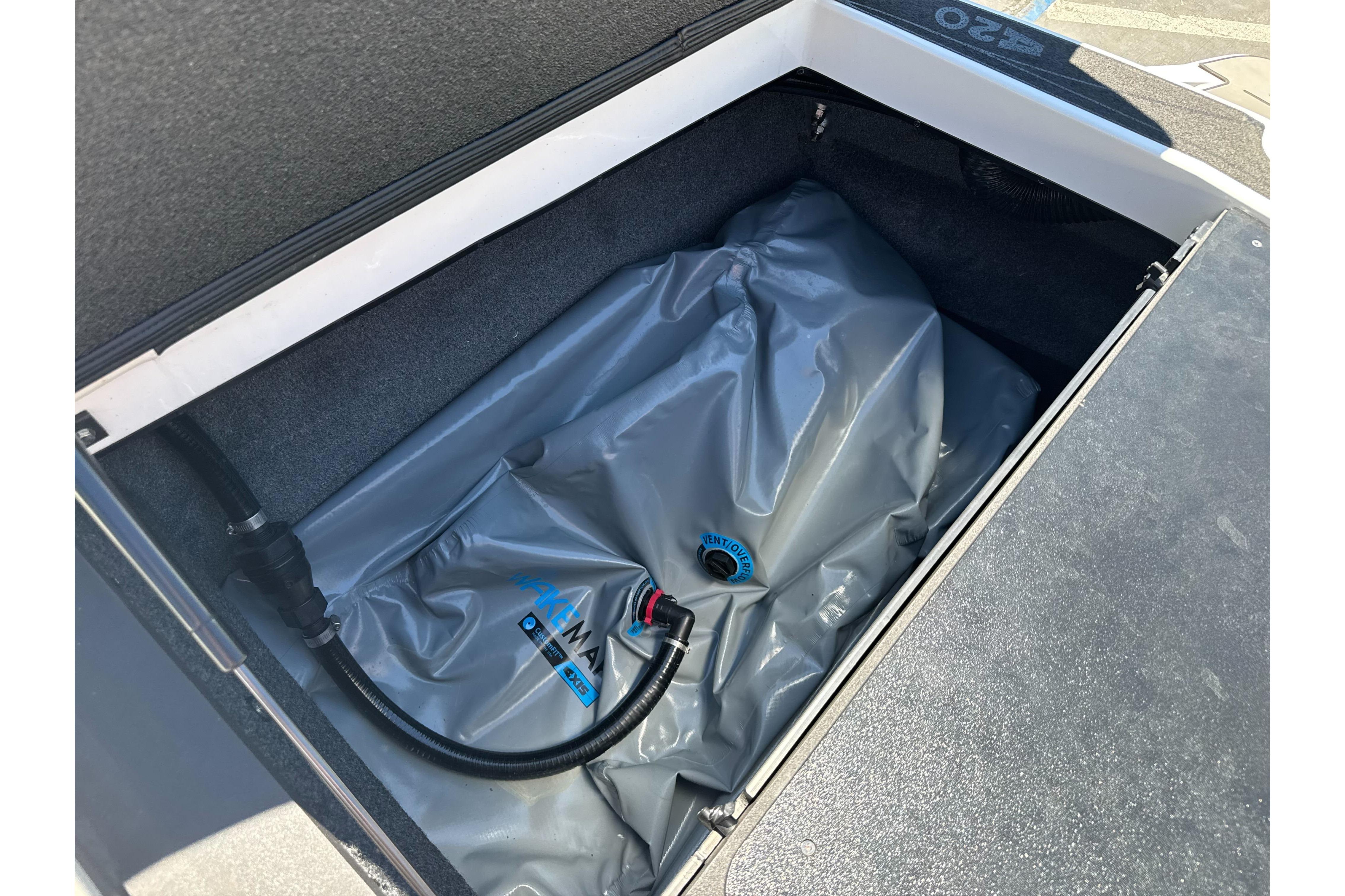 2015 Axis A20 boat ballast compartment with gray ballast bag and hose connection.