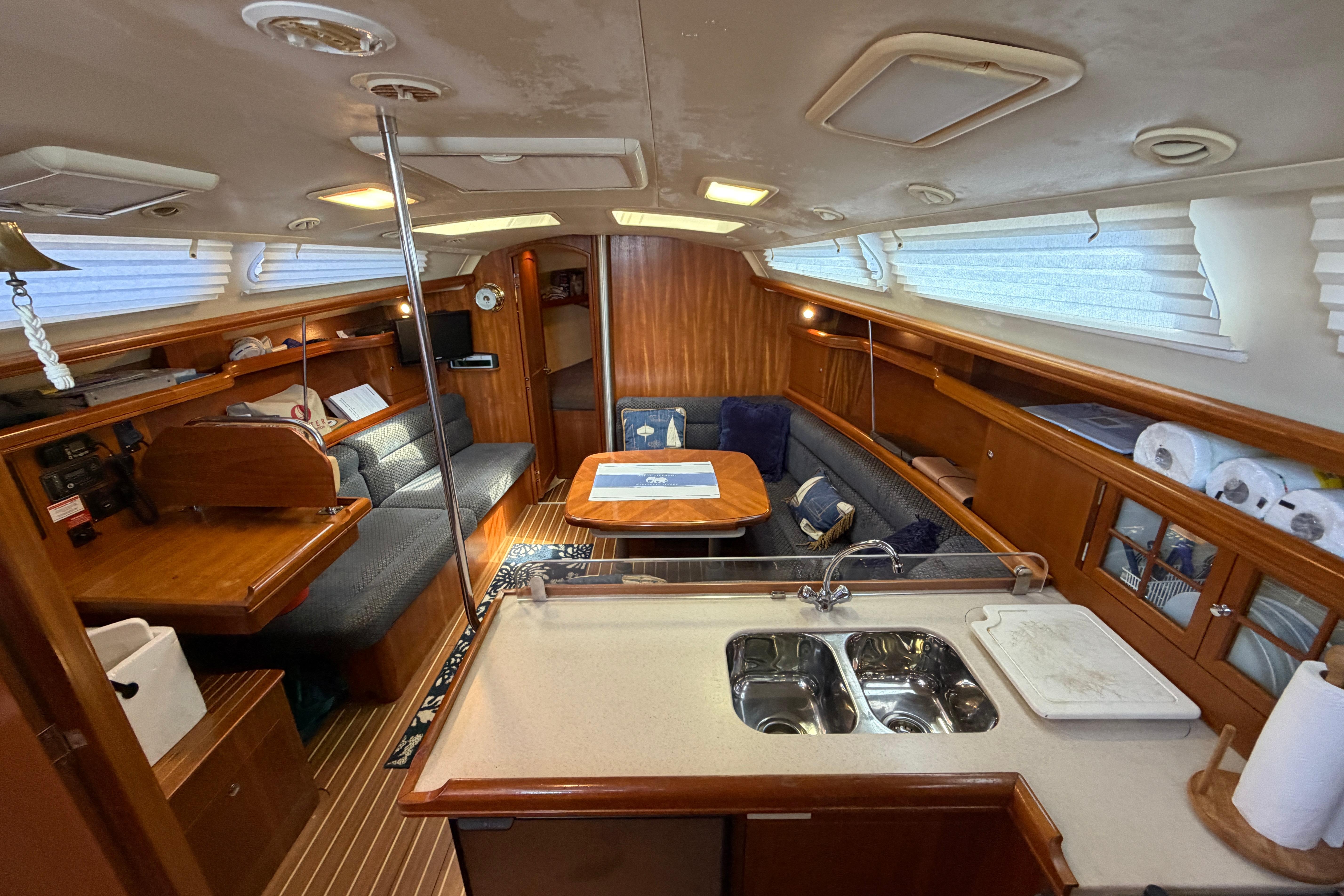 Interior of a 2005 Hunter 38 sailboat with cozy seating and kitchen area.