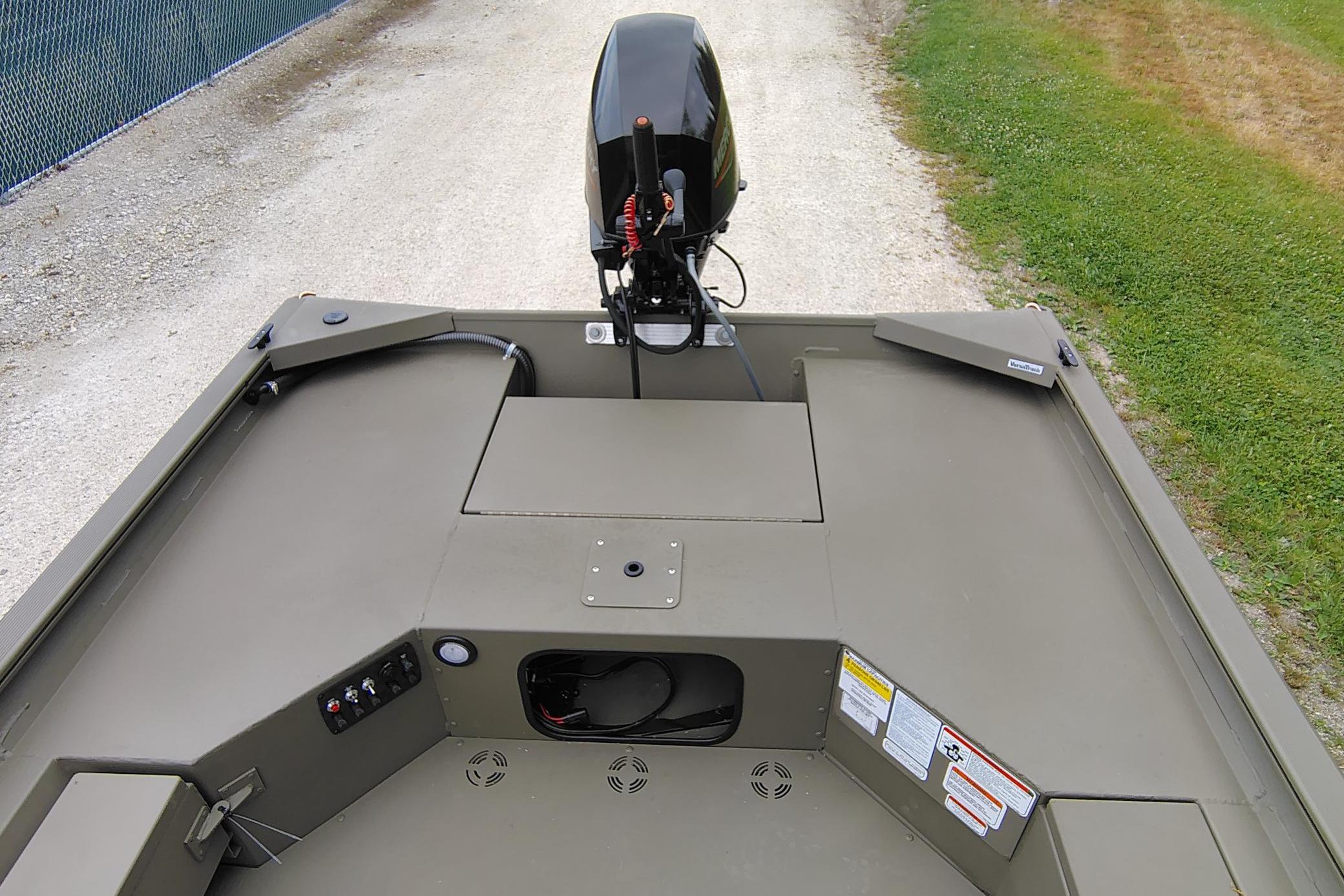 2026 Tracker Grizzly 1654 T Sportsman boat interior with motor, on gravel path.