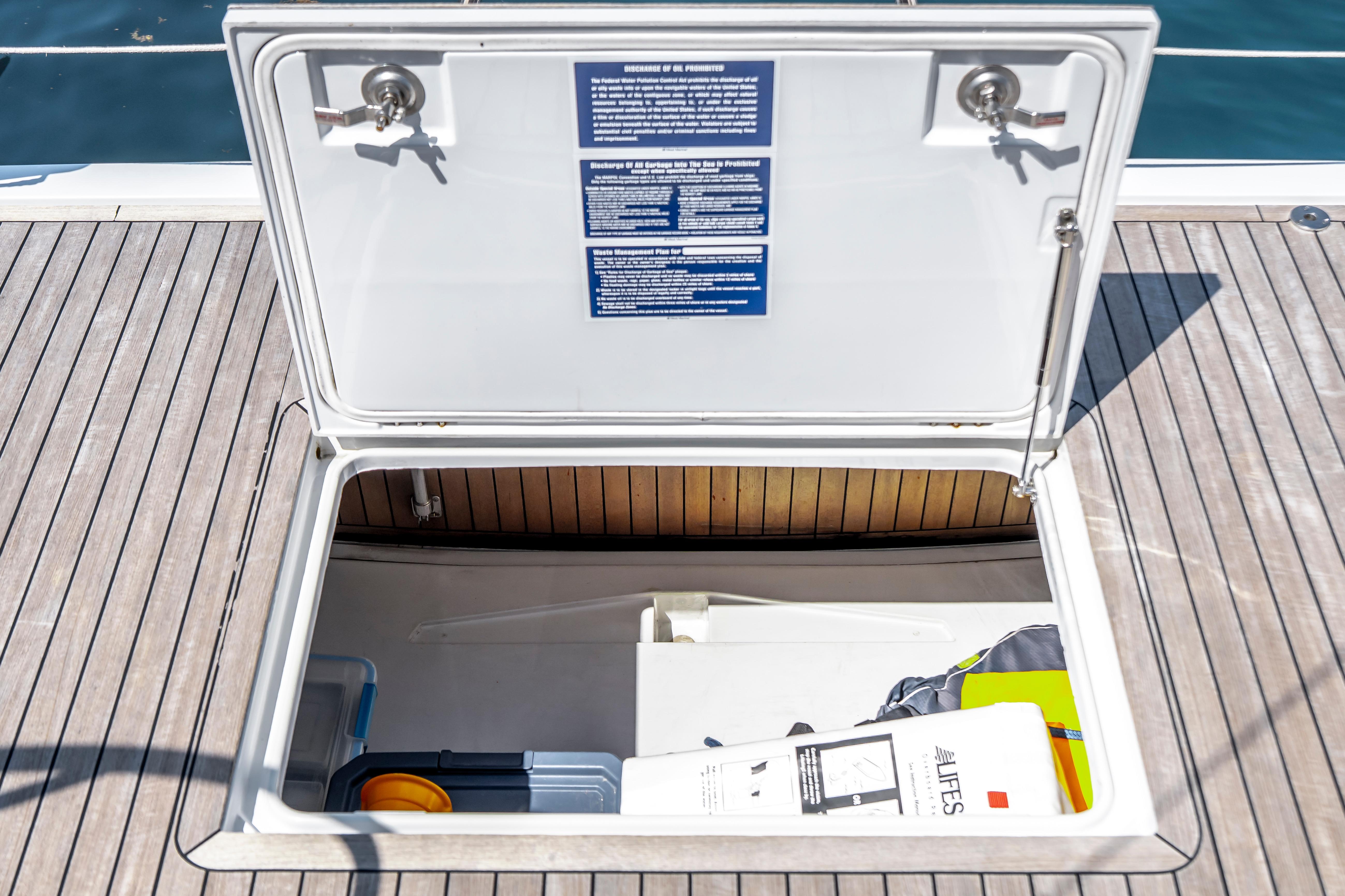 Open storage compartment on 2016 Grand Soleil 58 yacht deck, containing various items.