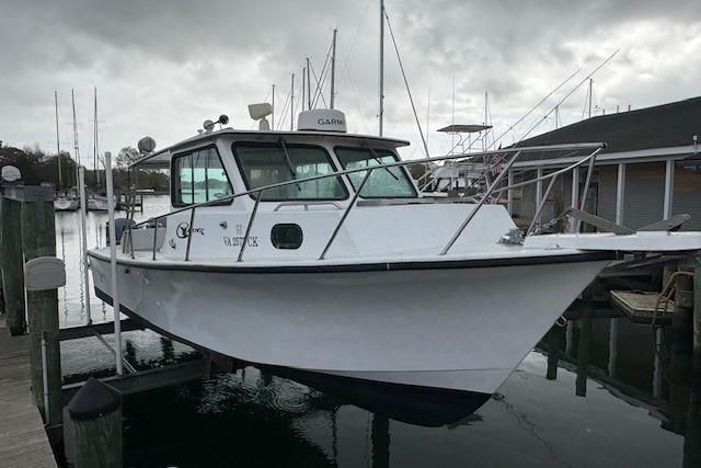 1989 C-Hawk 29 Sport Cabin boat docked at marina under cloudy skies.