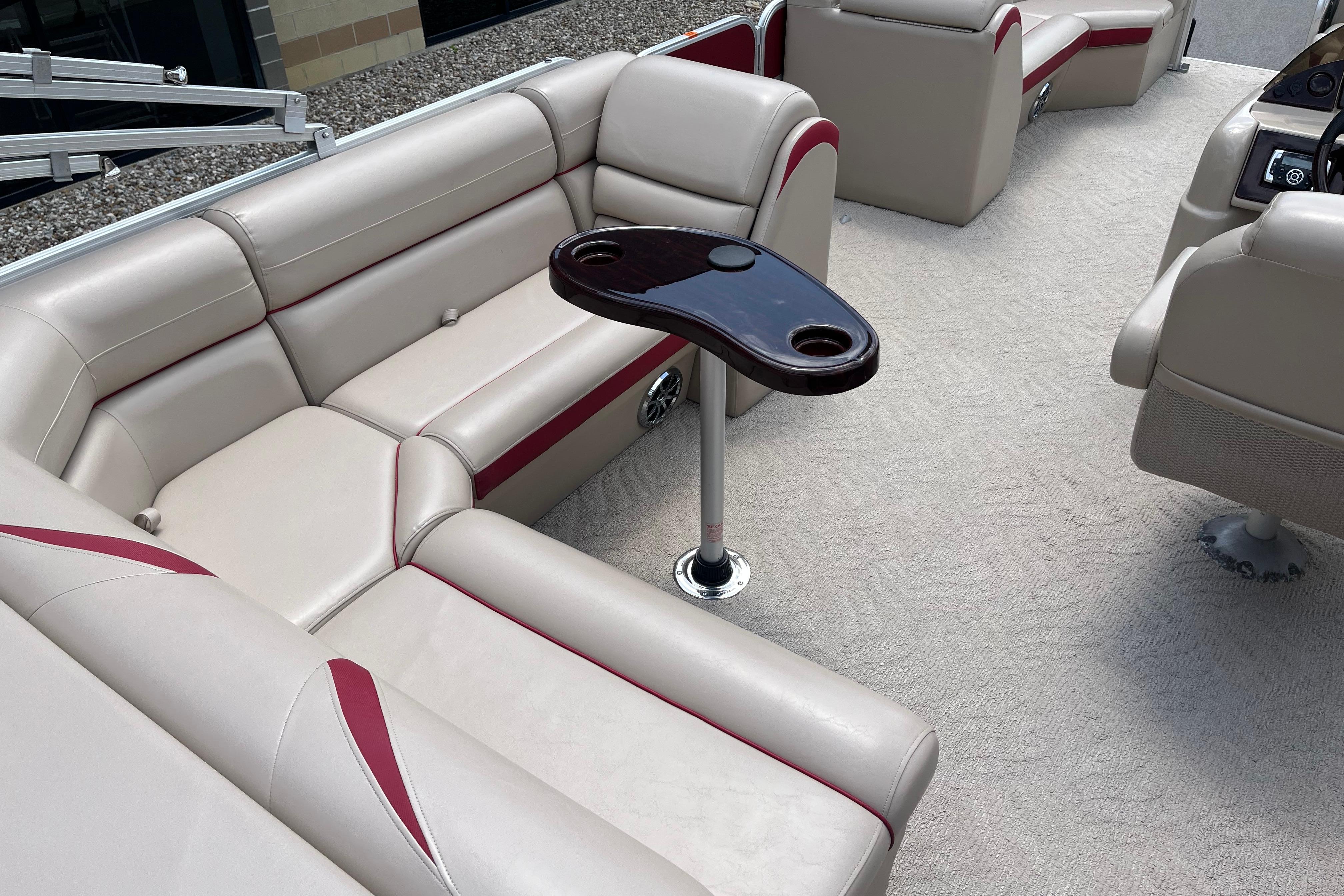 Luxurious interior of a 2013 Berkshire 230CL CTS pontoon boat with beige seating and table.