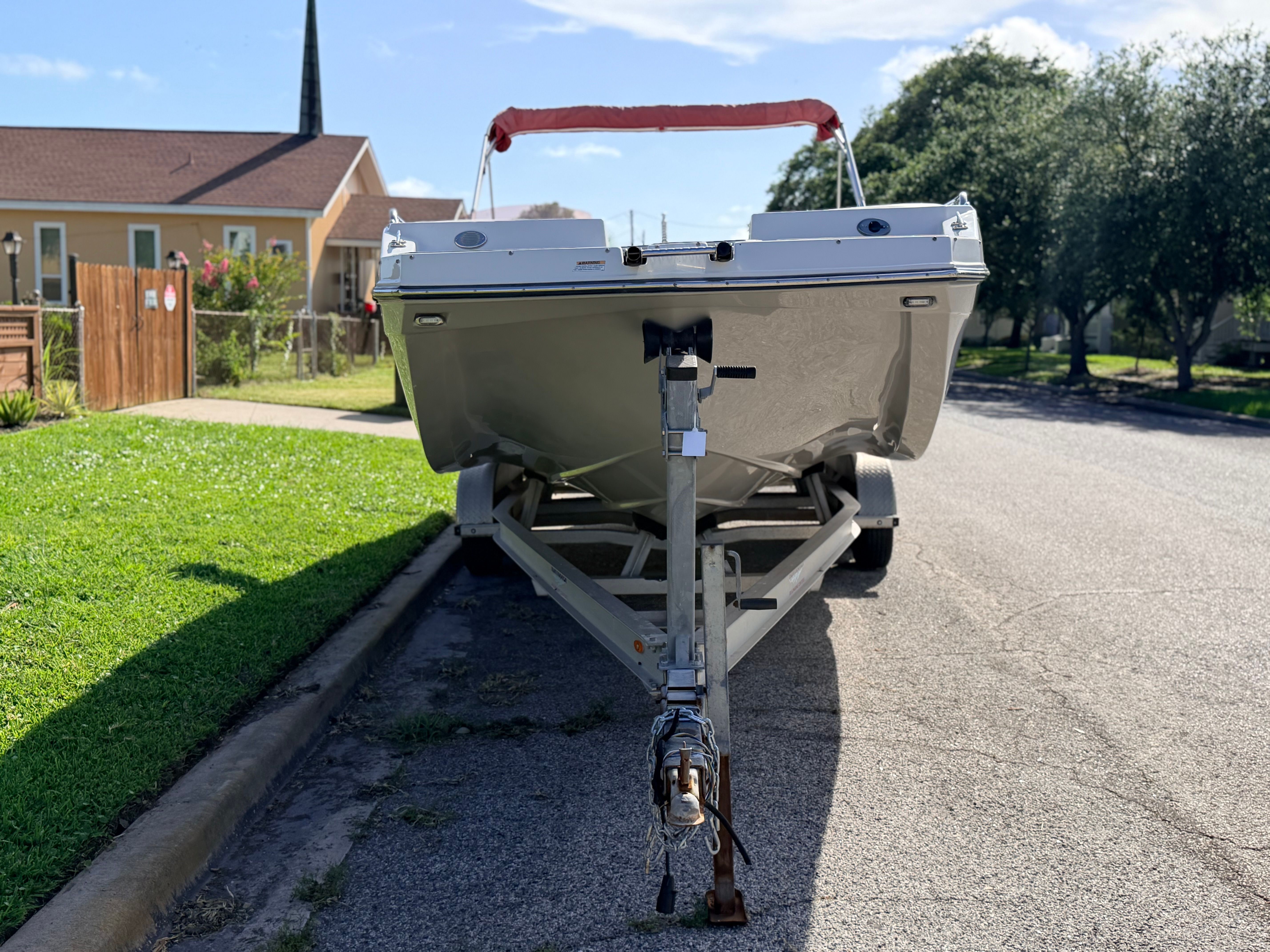 A Starcraft SVX 231 boat on a trailer in a residential street.