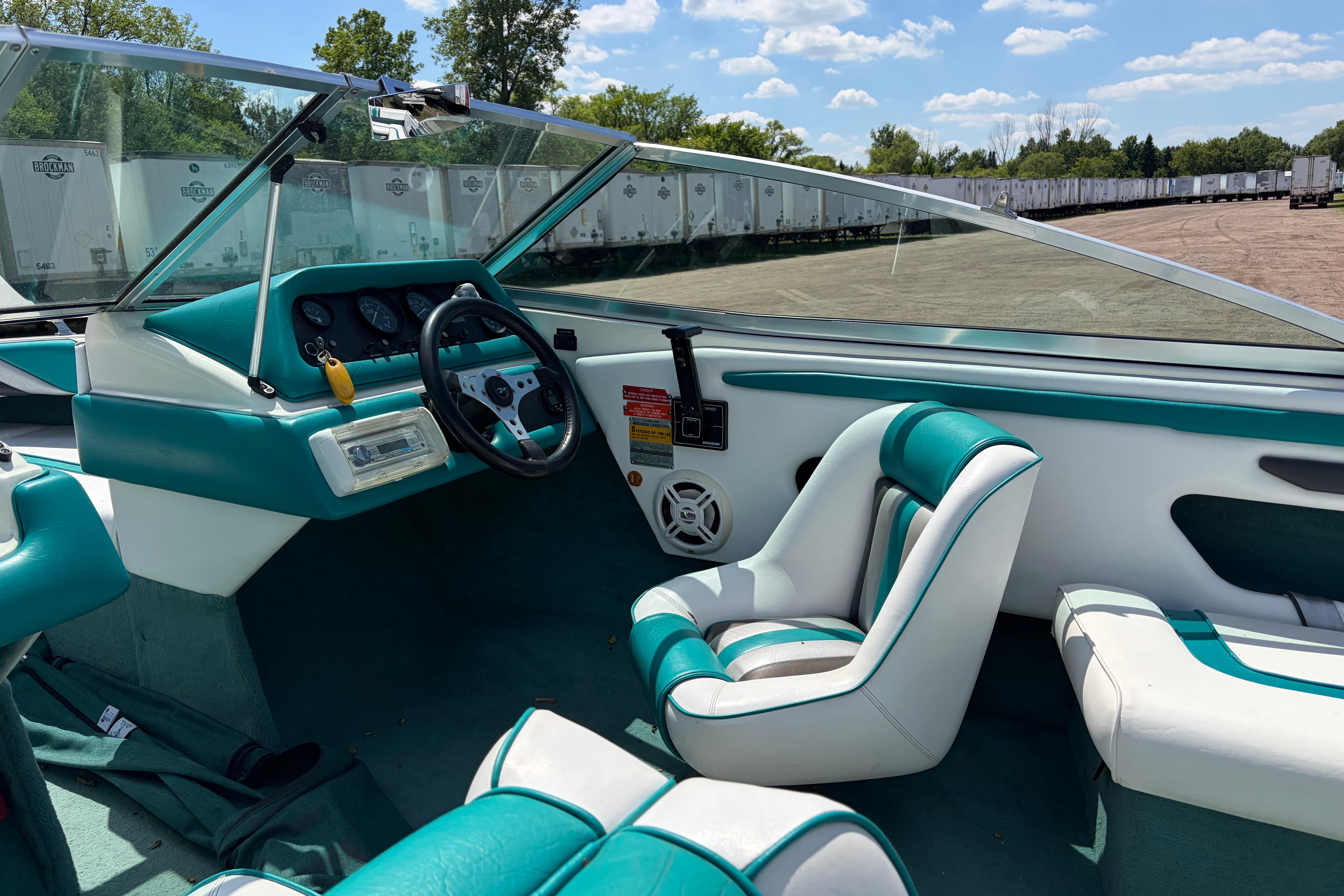 Interior of a 1990 Sea Ray 180 Bow Rider boat with teal and white seating.