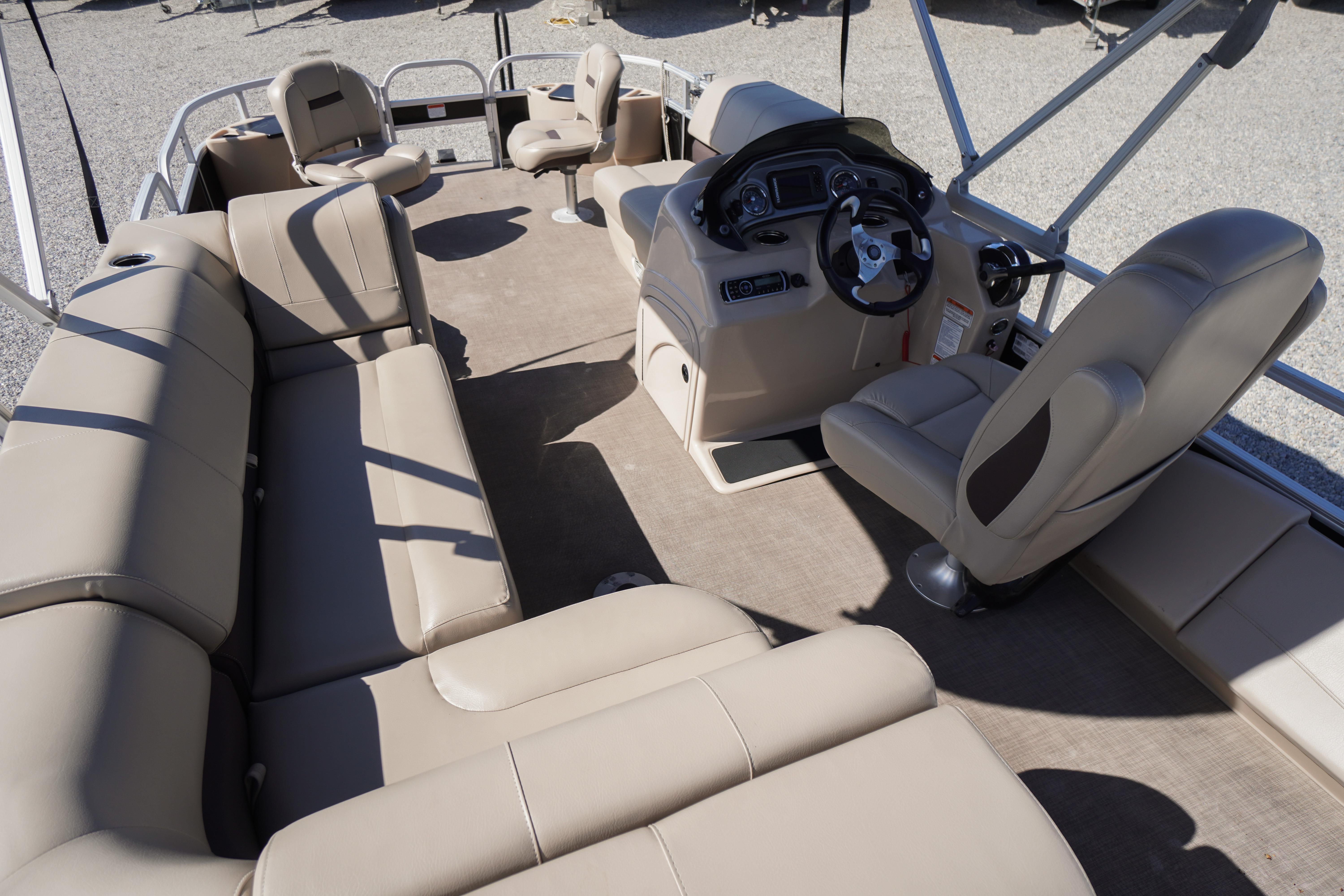 2019 SUNTRACKER Fishin' Barge 22 DLX interior with beige seating and steering console.