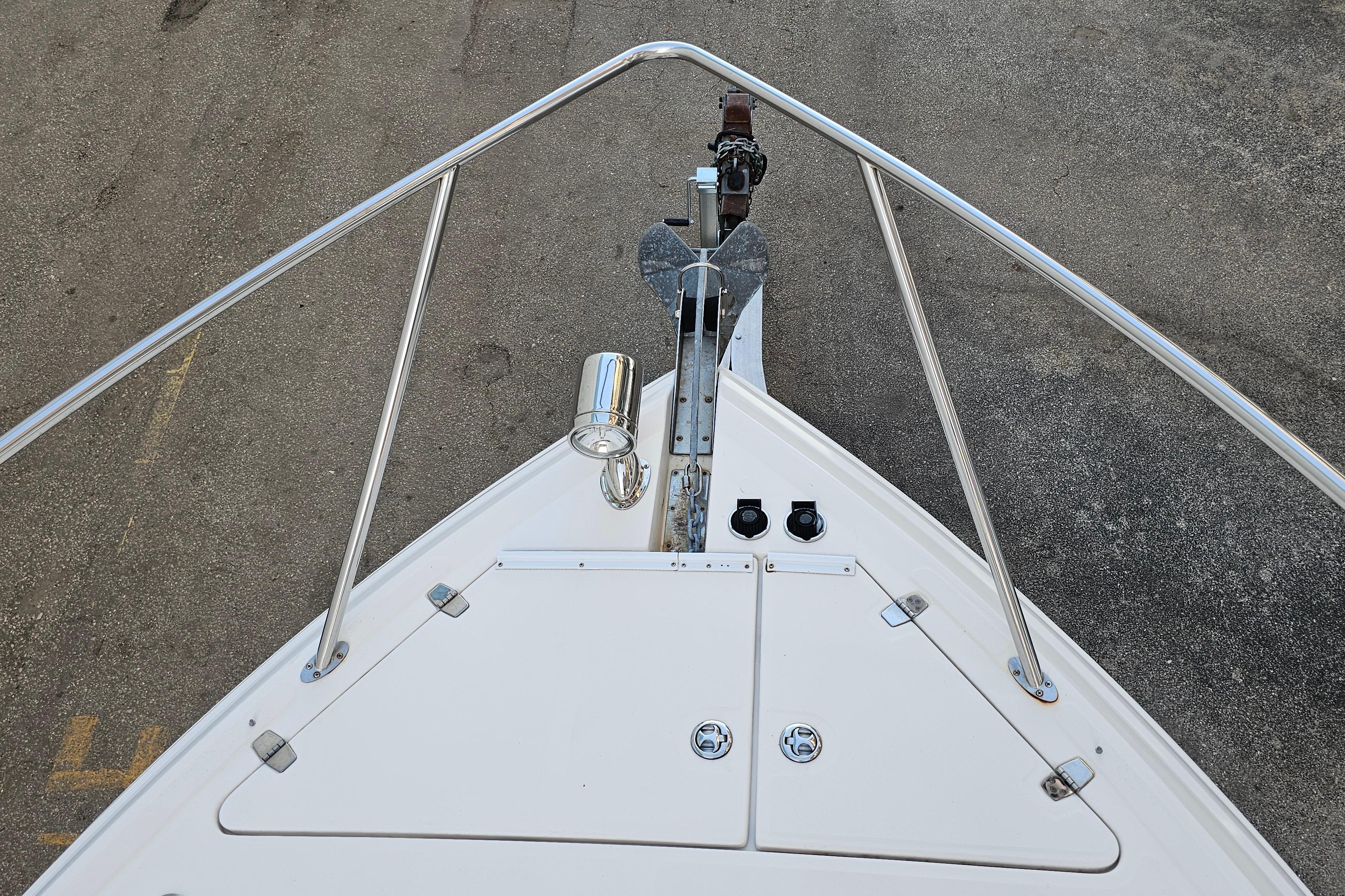 Bow view of 2005 Regal 3060 Window Express boat with anchor and railing.