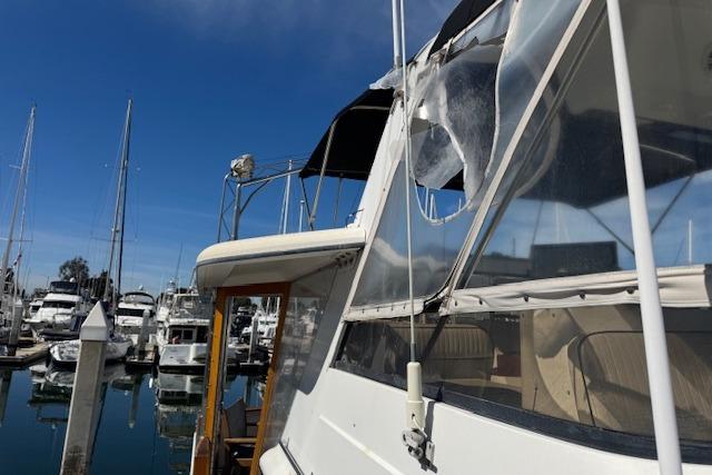 1986 Carver 4207 Aft Cabin Motor Yacht docked at marina under clear blue sky.