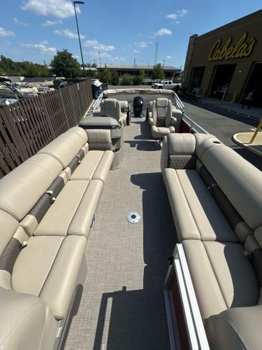 2025 Sun Tracker Party Barge 24 DLX with spacious seating at Cabela's parking lot.
