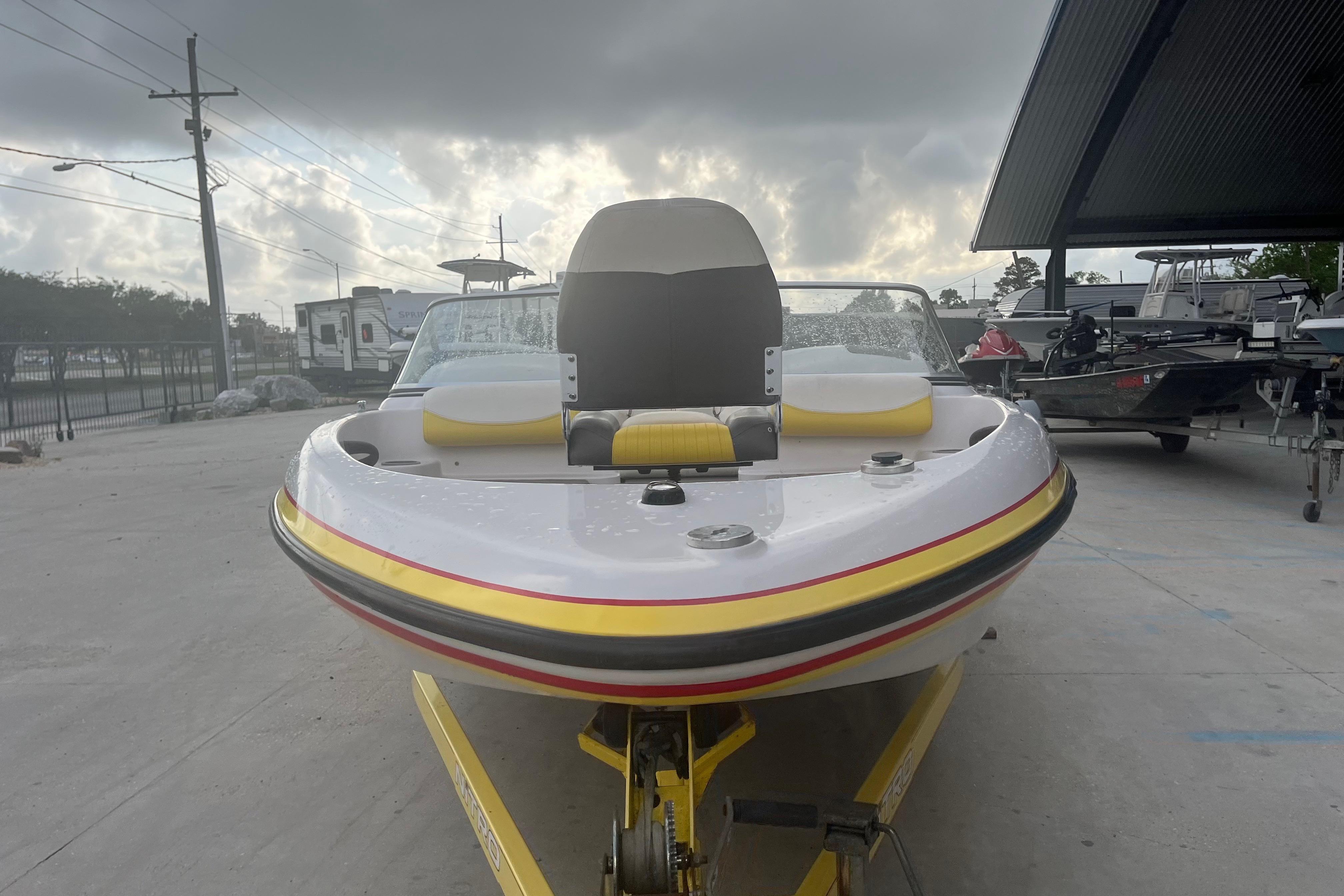 2006 Nitro 189 Sport boat on trailer, parked outdoors under cloudy sky.
