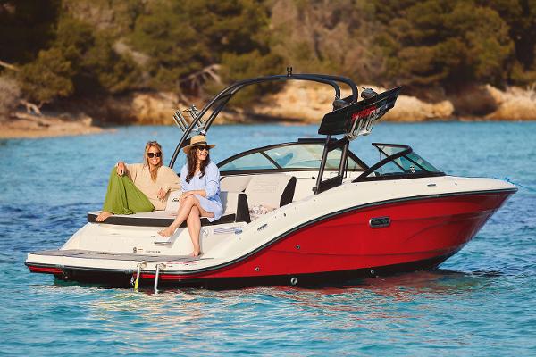 Manufacturer Provided Image: 2025 Sea Ray SPX 210 boat on clear blue water with two people relaxing.