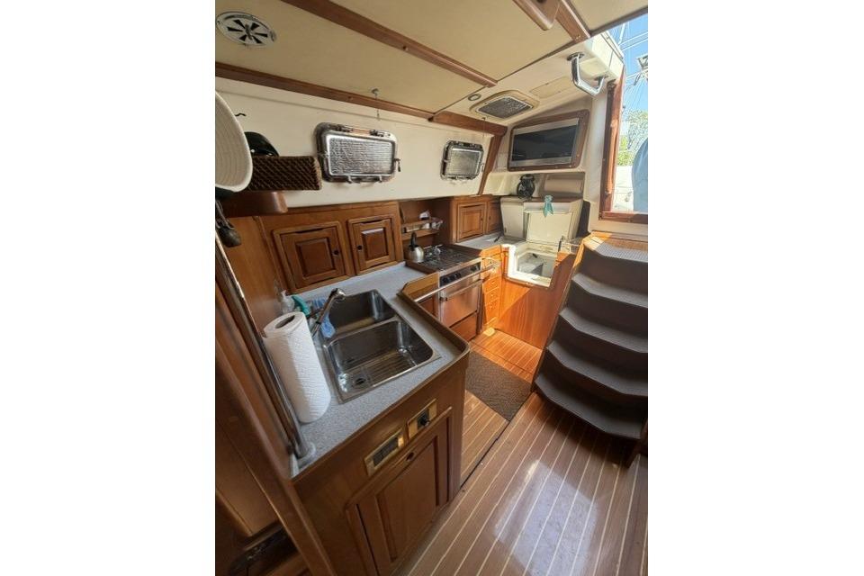 Interior of 2002 Saga 43 yacht kitchen with wooden cabinetry and modern appliances.