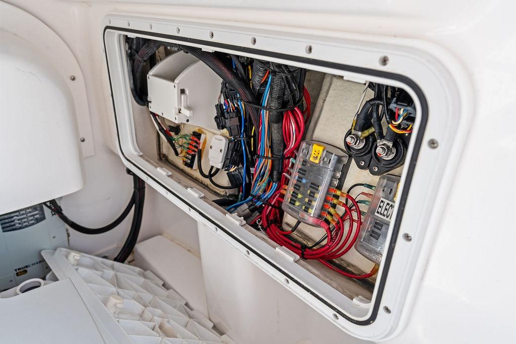 Electrical wiring panel inside 2023 Everglades 243 Center Console boat, showcasing organized cables and components.