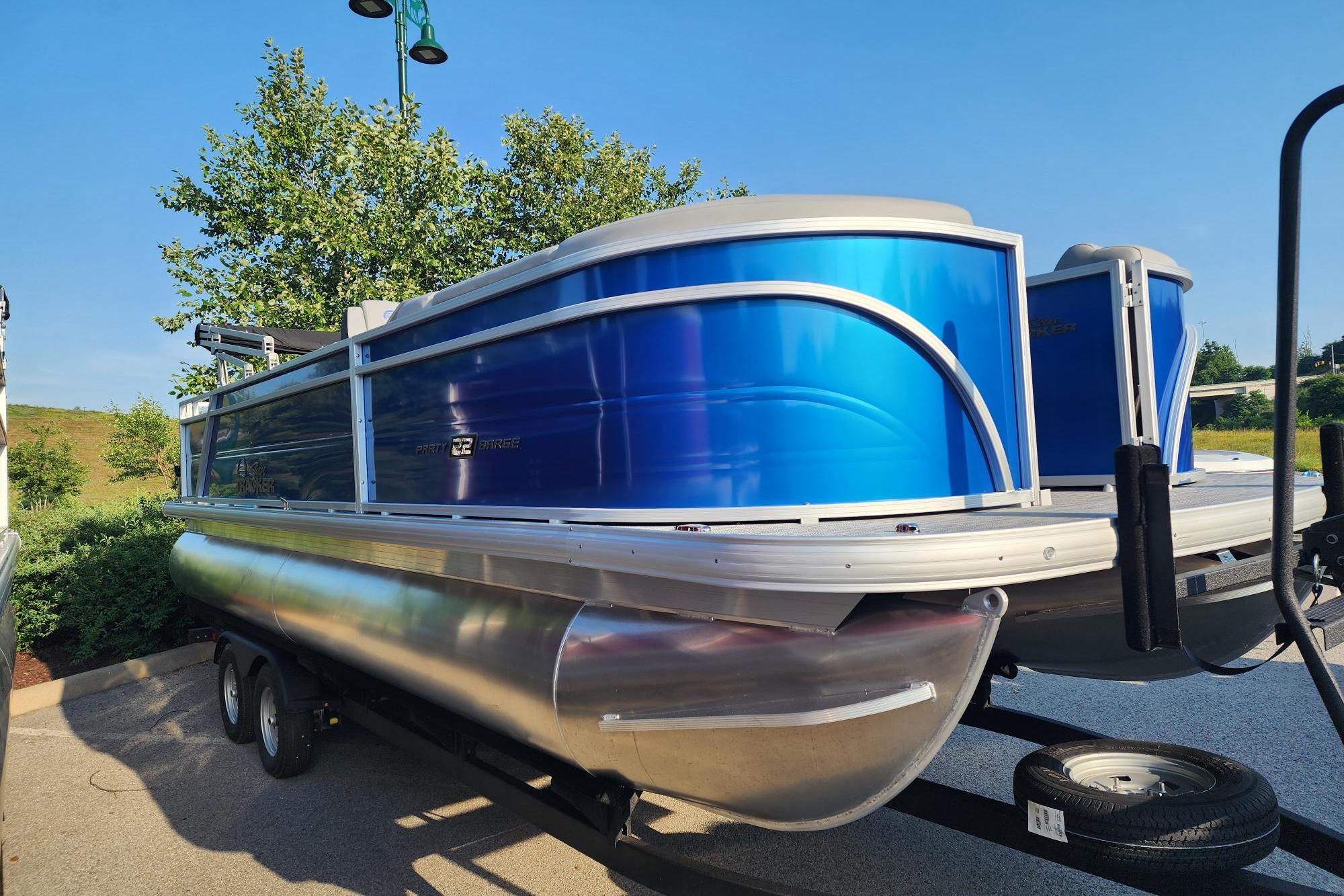 2026 Sun Tracker Party Barge 22 RF DLX pontoon boat with vibrant blue exterior.