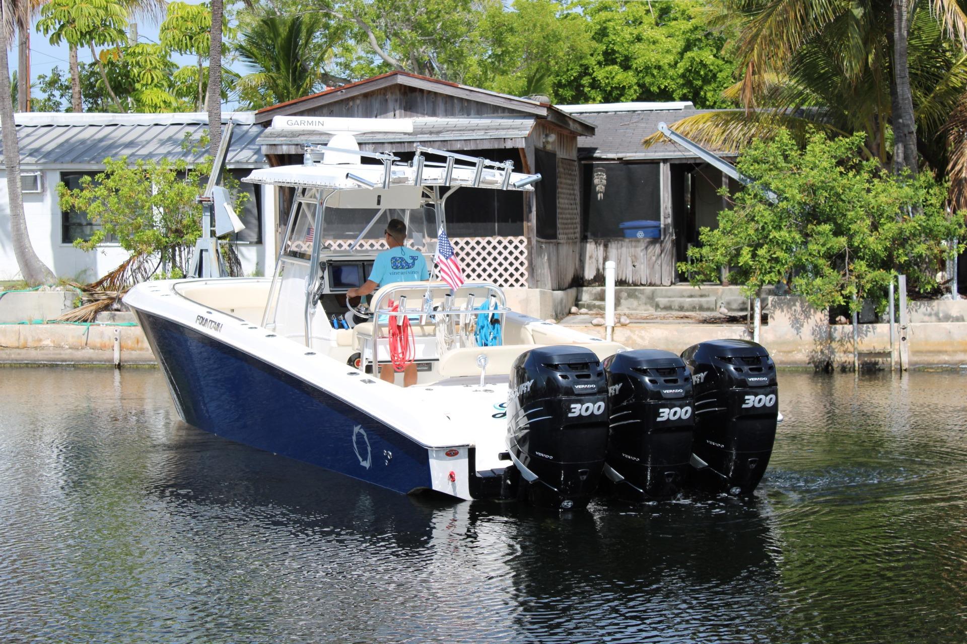 2007 Fountain 34 Center Console boat with four Mercury 300 engines on a calm waterway.